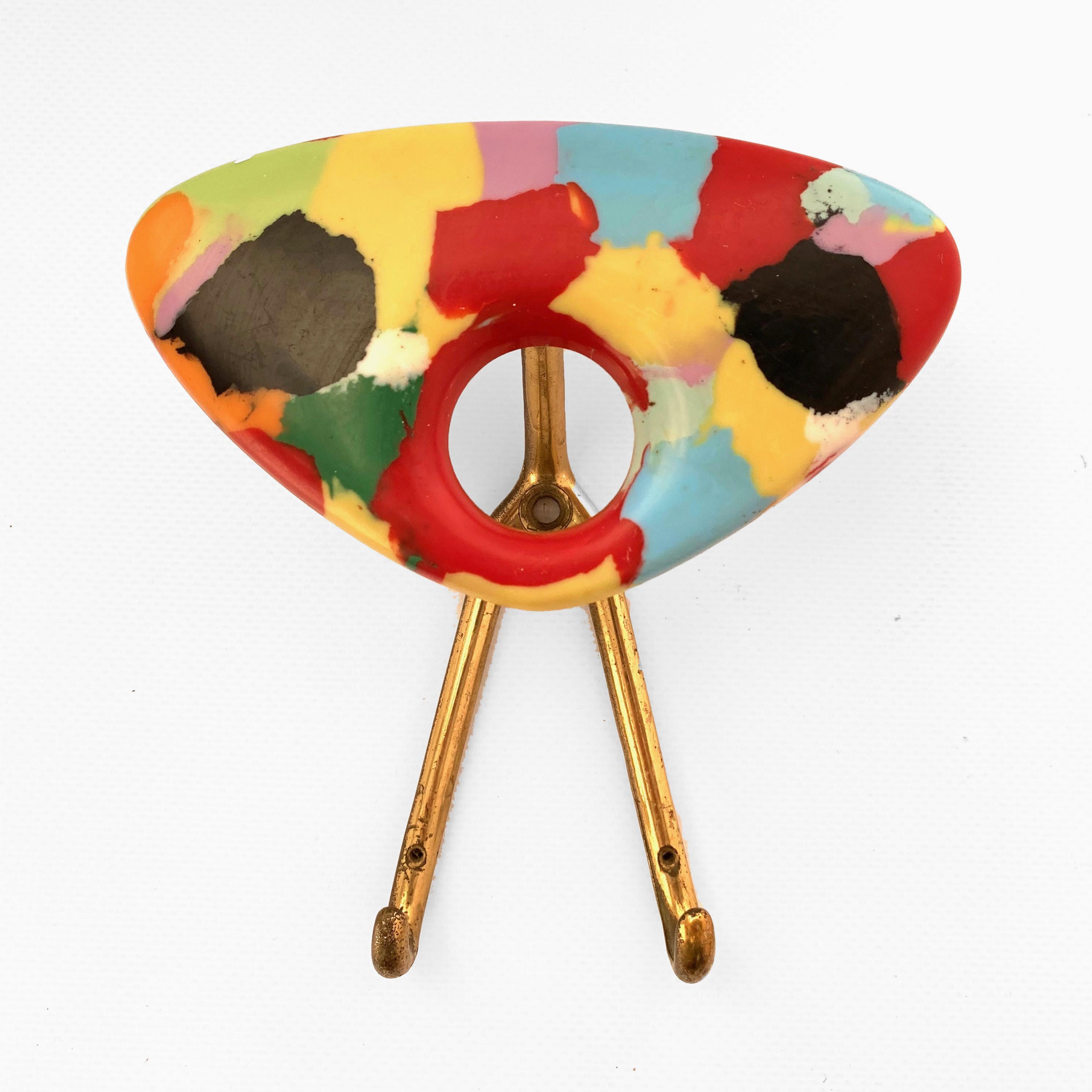 Coat hanger made of multicolored plastic and brass, Italy, 1950s.

Dimensions: Width 13.5 cm, depth 7 cm, height 15 cm.