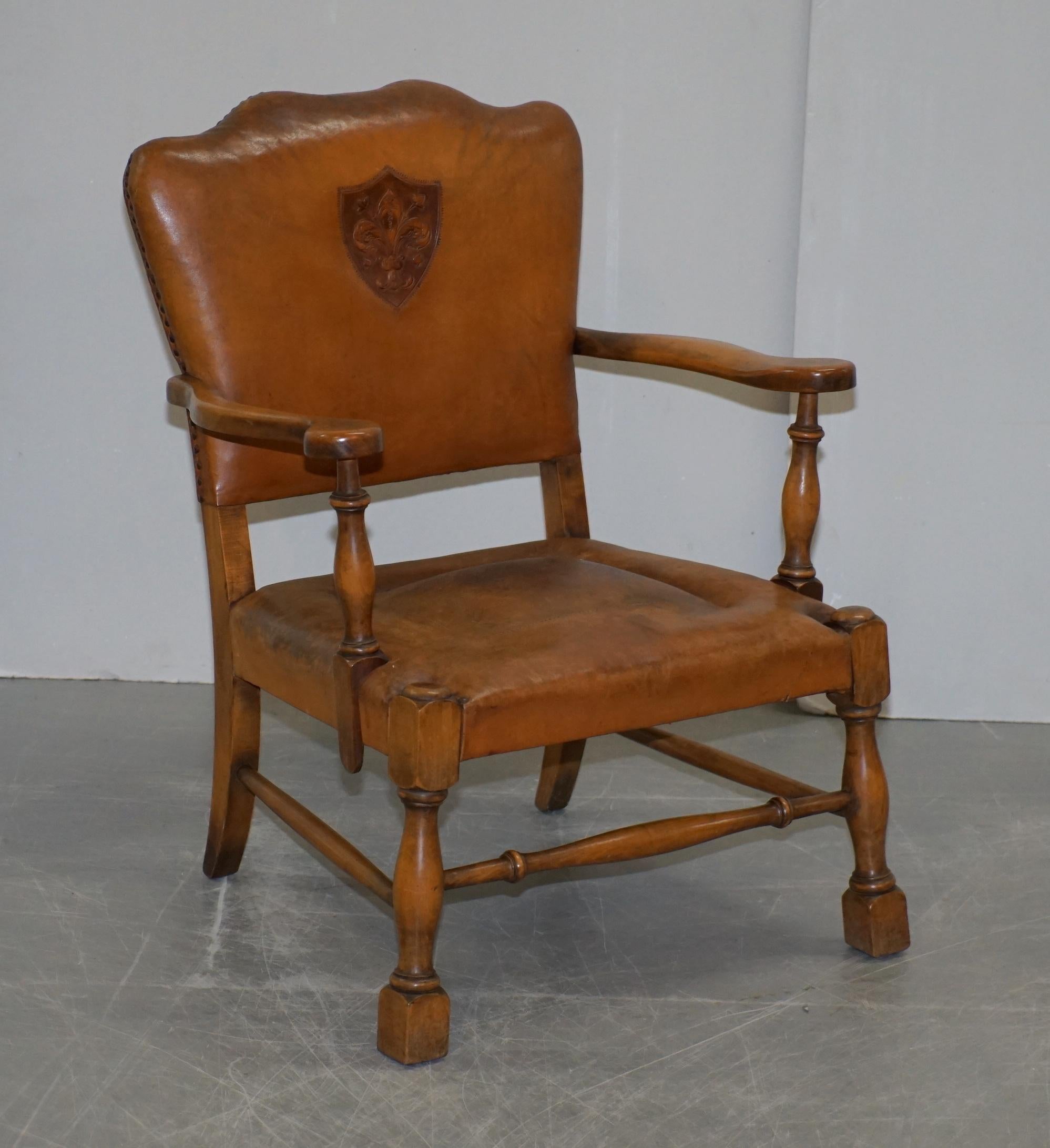 We are delighted to offer for sale this lovely pair of Edwardian smart club armchairs with oak frames and brown leather upholstery that have embossed coat of arms armorial crests in the back

These chairs have the original leather upholstery, one