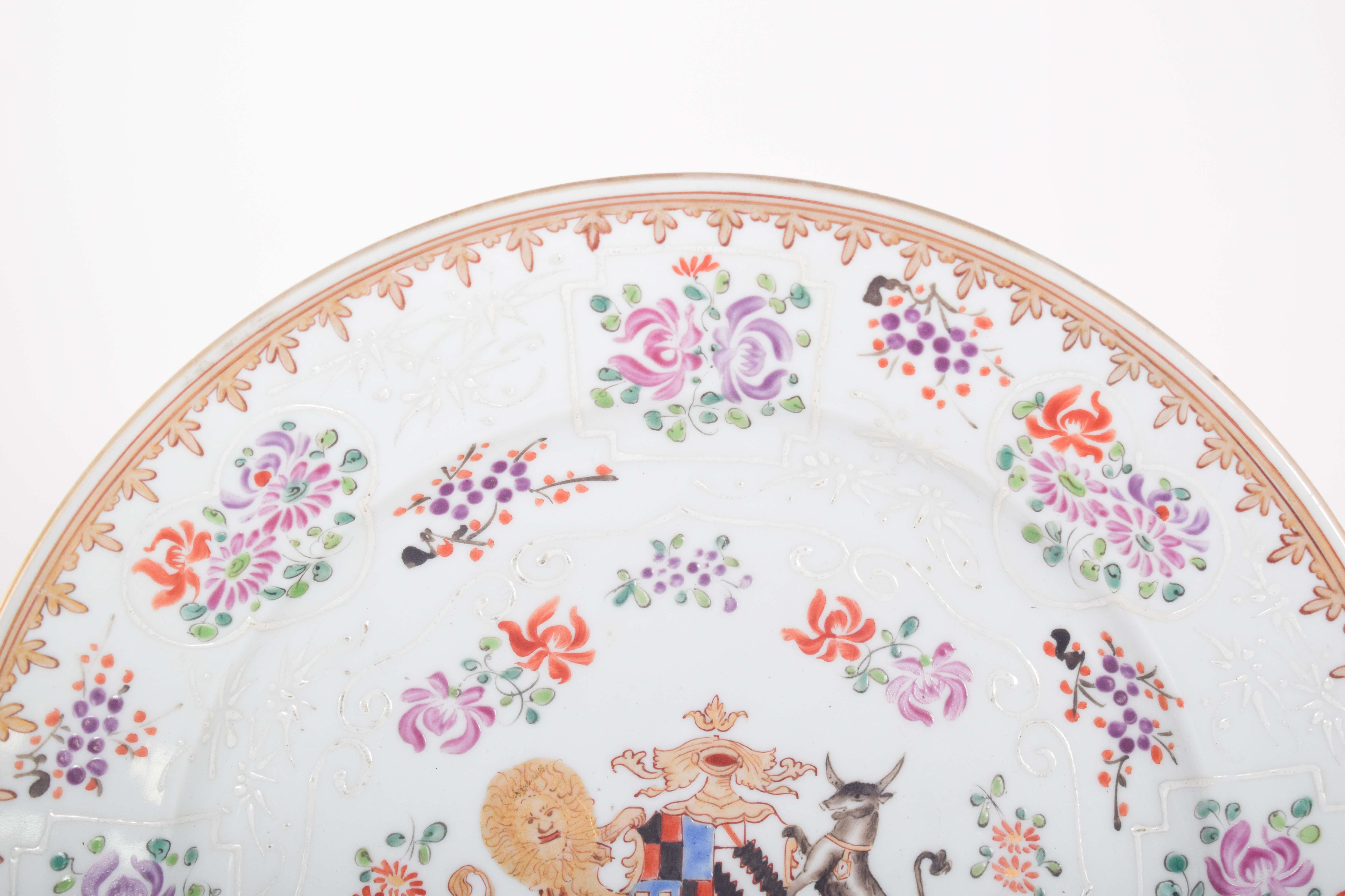 Wappenteller aus chinesischem Exportporzellan, Qing-Dynastie, Qianlong-Periode (1736-1795), möglicherweise auf Bestellung gefertigt. Polychrome Verzierung mit Wappen, umgeben von zarten Blumen in Rot-, Purpur-, Grün- und Weißschattierungen
Der