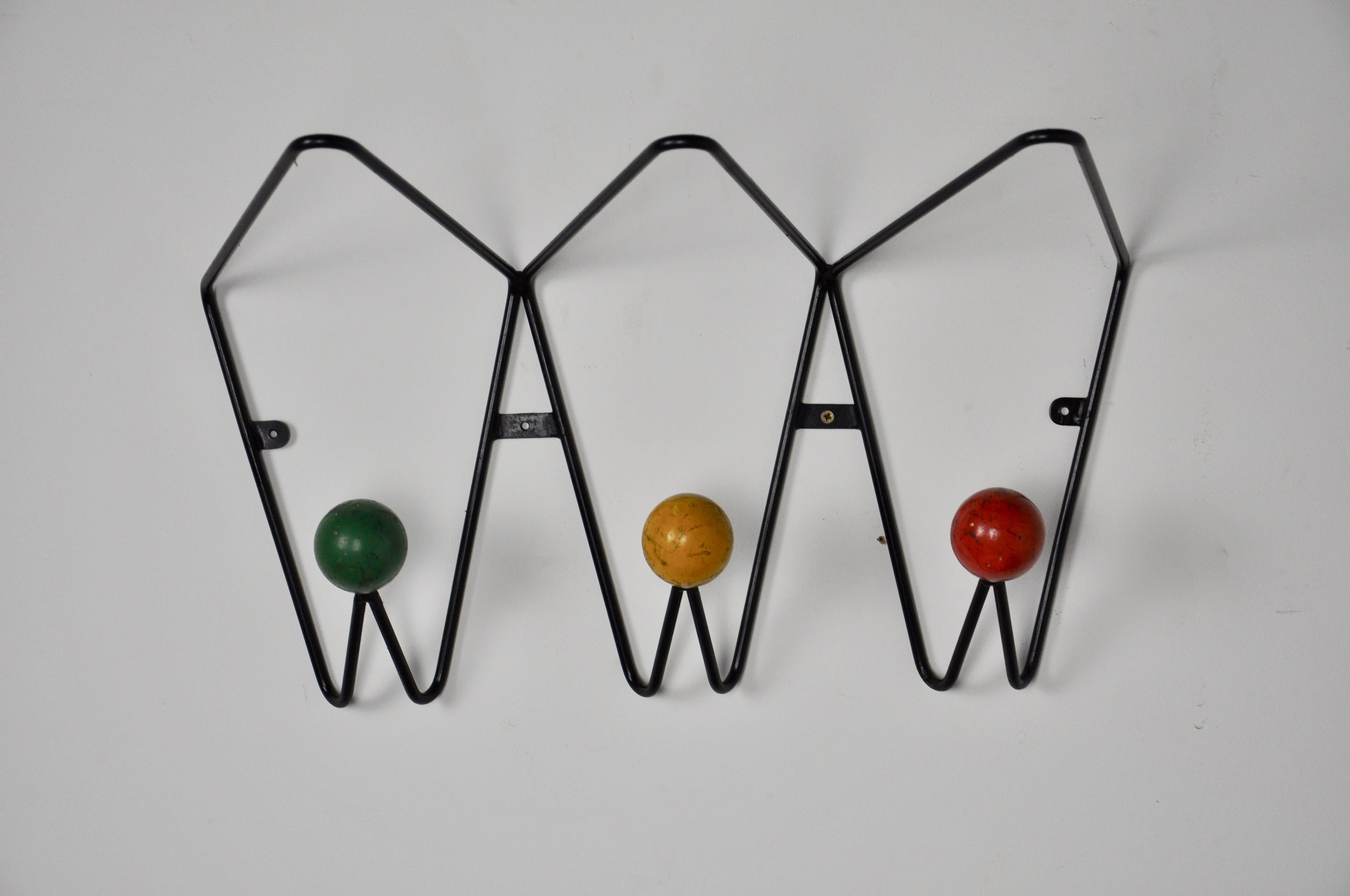 Coat rack composed of 3 balls of color green yellow red in wood. Structure in metal of black color. The balls have a patina.