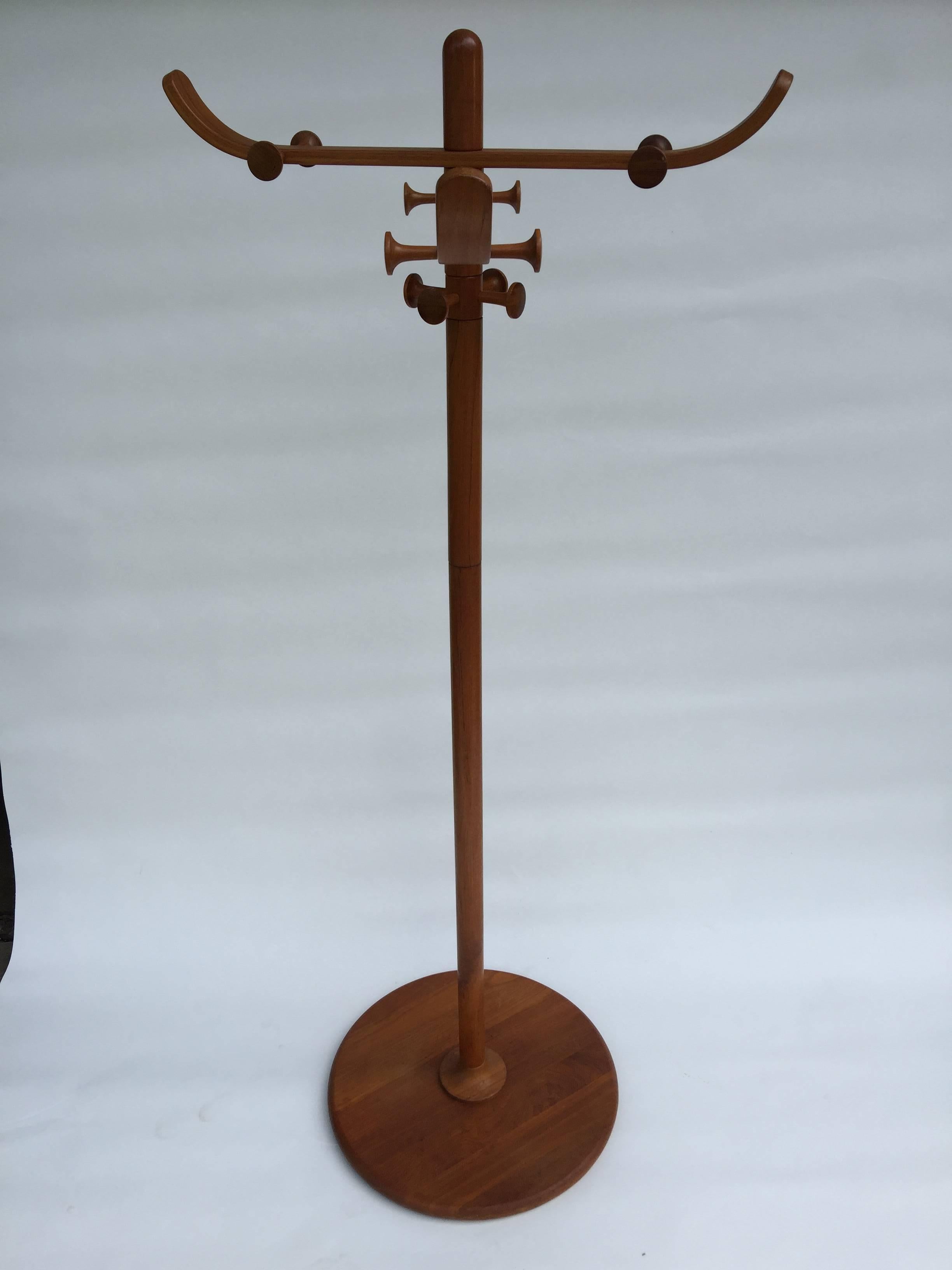 Beautiful and useful teak coat rack with rotating hooks. A round base supports the upright pole and bentwood arms and hooks for hanging coats hats umbrellas and more. Beautifully designed and crafted would make a great addition to any entryway or