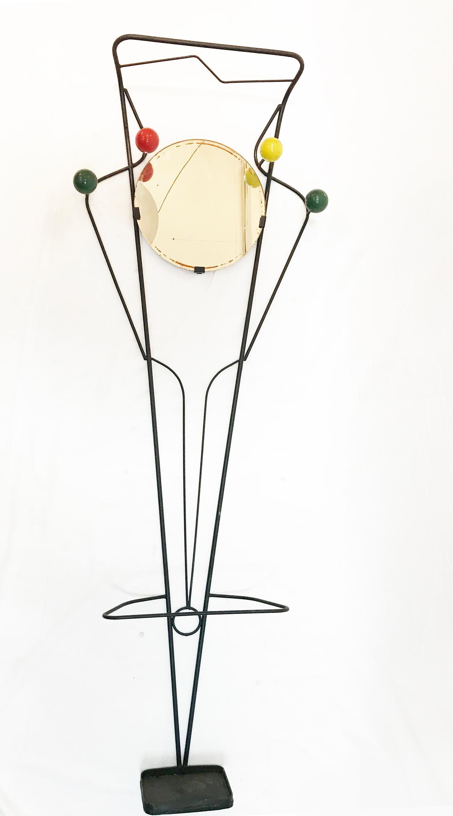 wall-mounted coat and umbrella rak, in the style of Roger Feraud, it features 4 hangers with beautiful patina in yellow red and green, the rak curves down on top providing a short of shelf for huts or hand bags and at the middle to bottom is the