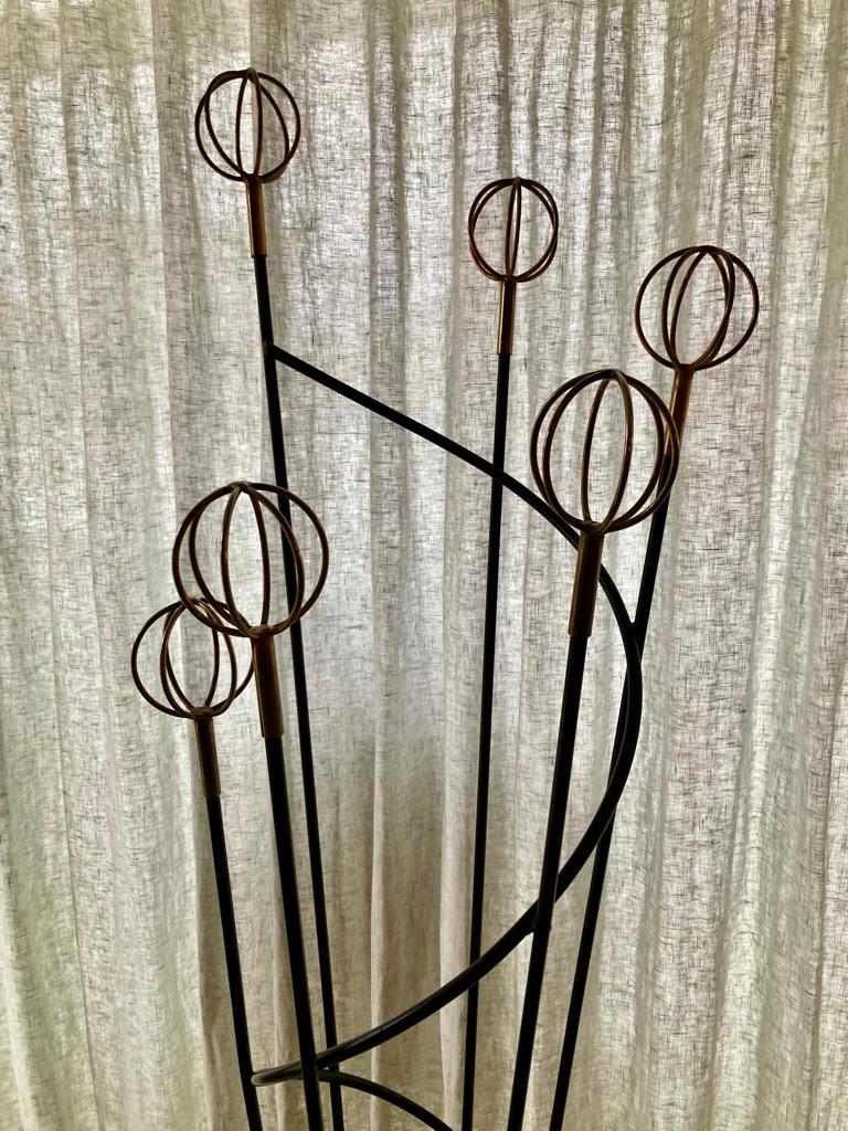 Mid-Century coat rack with a swirl designed by Roger Feraud. Black wrought iron with golden balls in a graphic and very elegant design.