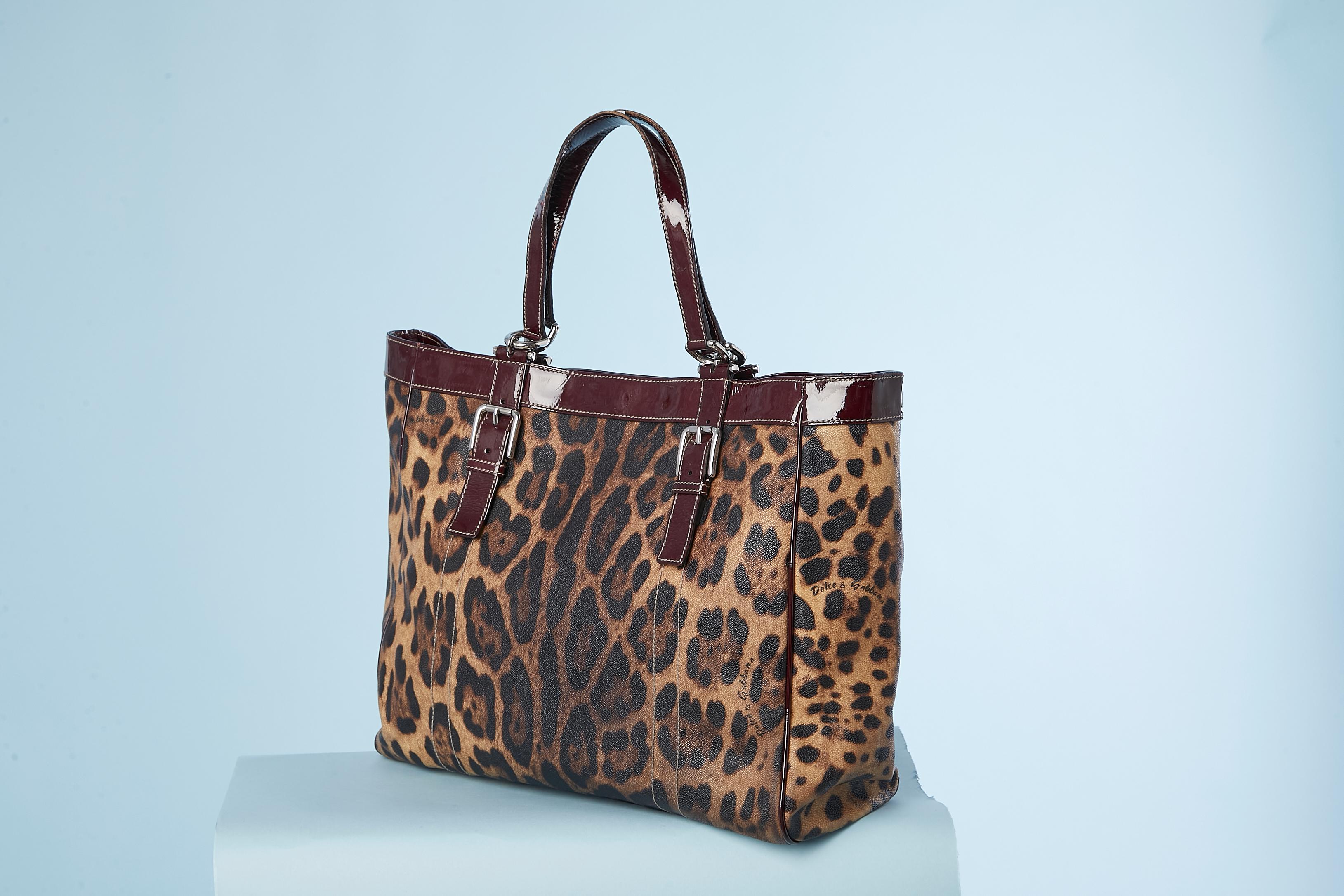 Coated leopard printed canevas and patent leather details. One outside pocket with zip; One inside pocket with zip and one small without ( mobile phone pocket) One snap in the middle and 2 straps with snaps as well ( to close the bag) . Brown cotton