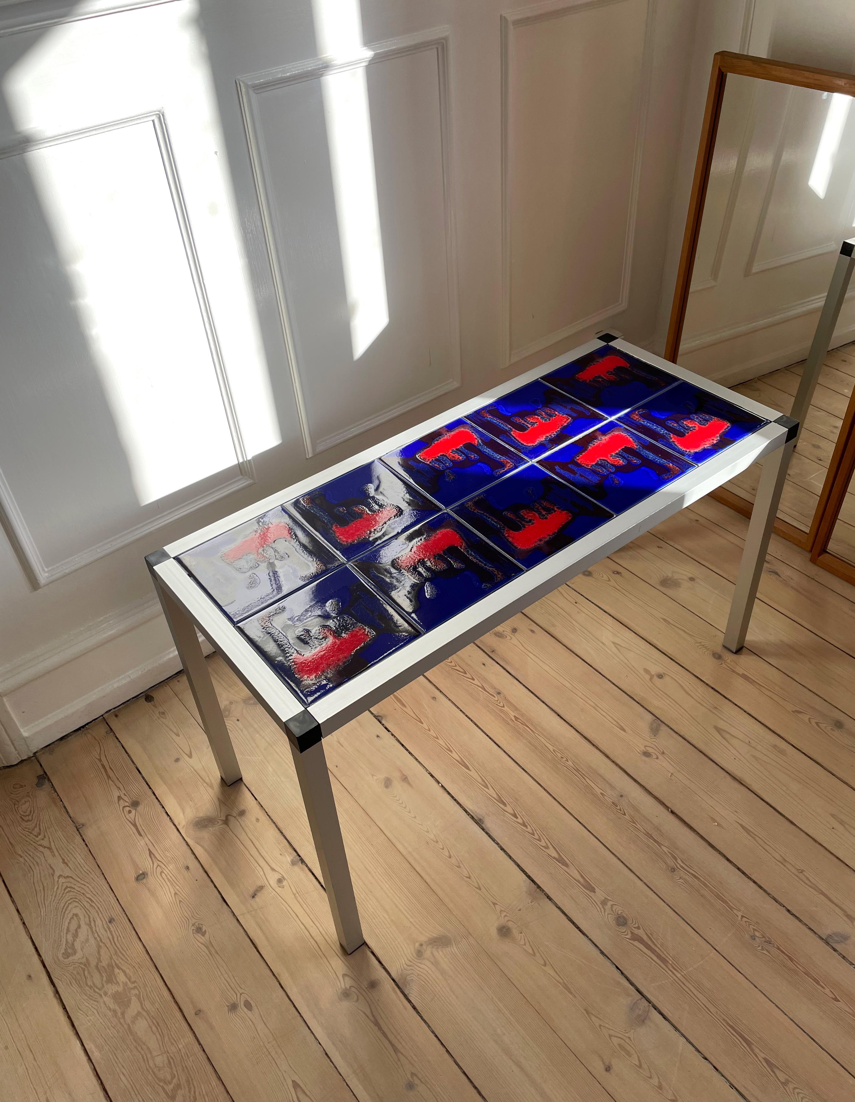 Eye-catching rectangular coffee side table with ten large shiny glazed tiles - each tiles measures 15x15 cm/5.9 in. Glaze in rich cobalt blue, black and almost neon hot coral with smooth organic decorative shapes mounted on wooden plate in a chrome