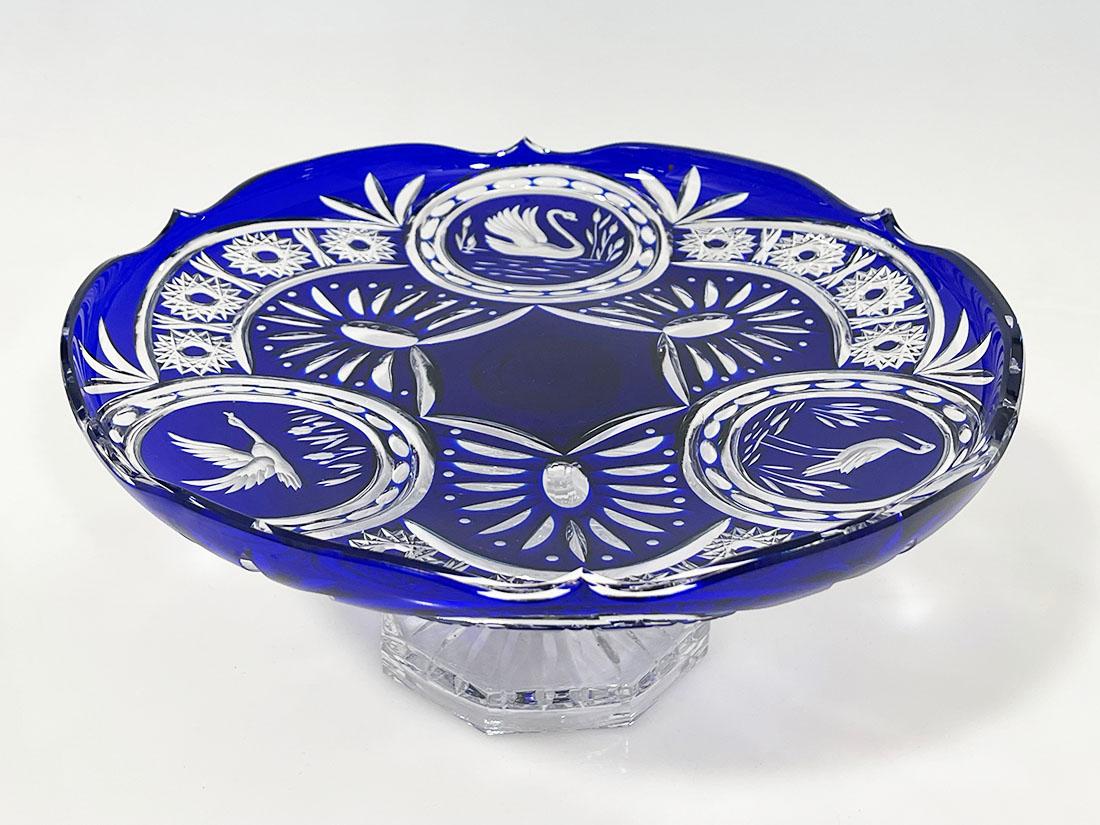 Assiette en cristal de Bohème taillé bleu cobalt sur pied décoré d'oiseaux

Une grande assiette à pied (bol) avec un décor d'oiseaux représentant un cygne, un héron et une oie en vol. Assiette ronde reposant sur une base octogonale aux bords