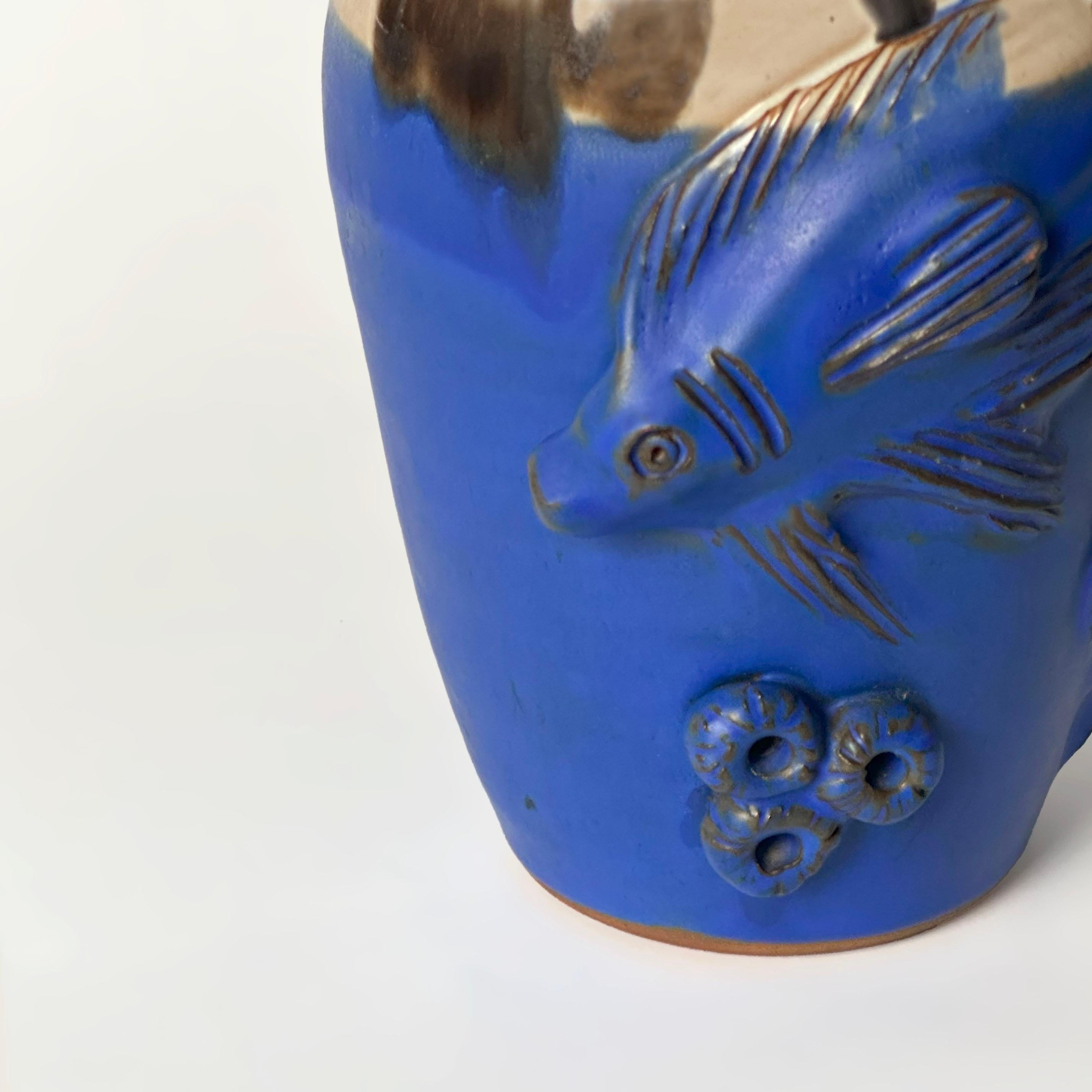 Hand-thrown and boldly expressive, this English studio pottery vase dates to the 1980s, reflecting the period’s renewed fascination with organic forms and artisanal glazing. Crafted from terracotta, its urn-shaped body is coated in a vivid cobalt