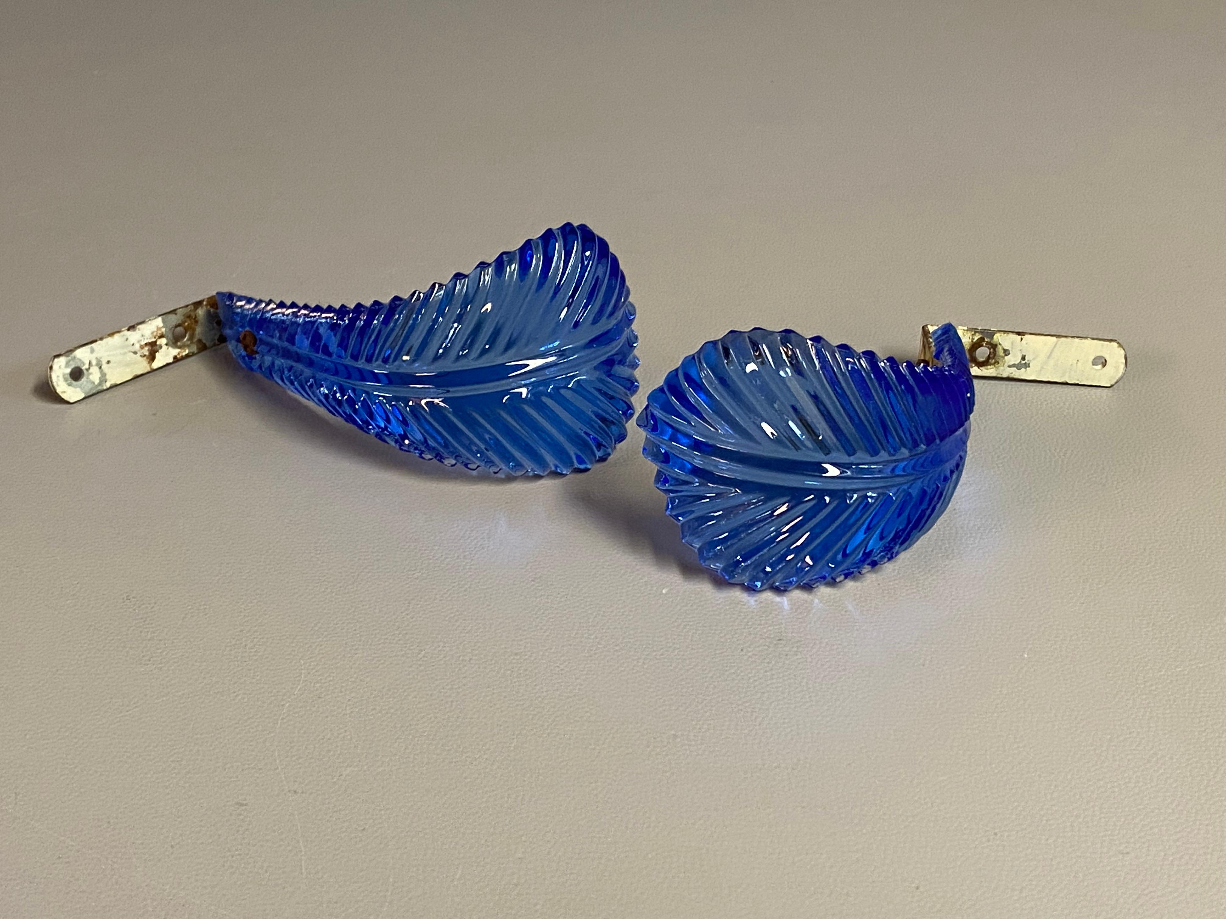 An elegant pair of Hollywood Regency era blue pressed glass feather curtain tie backs. The window dressing one needs to pull back the curtains to get some added light into a room. Curved cobalt blue glass in the form of a tapered feather backed with