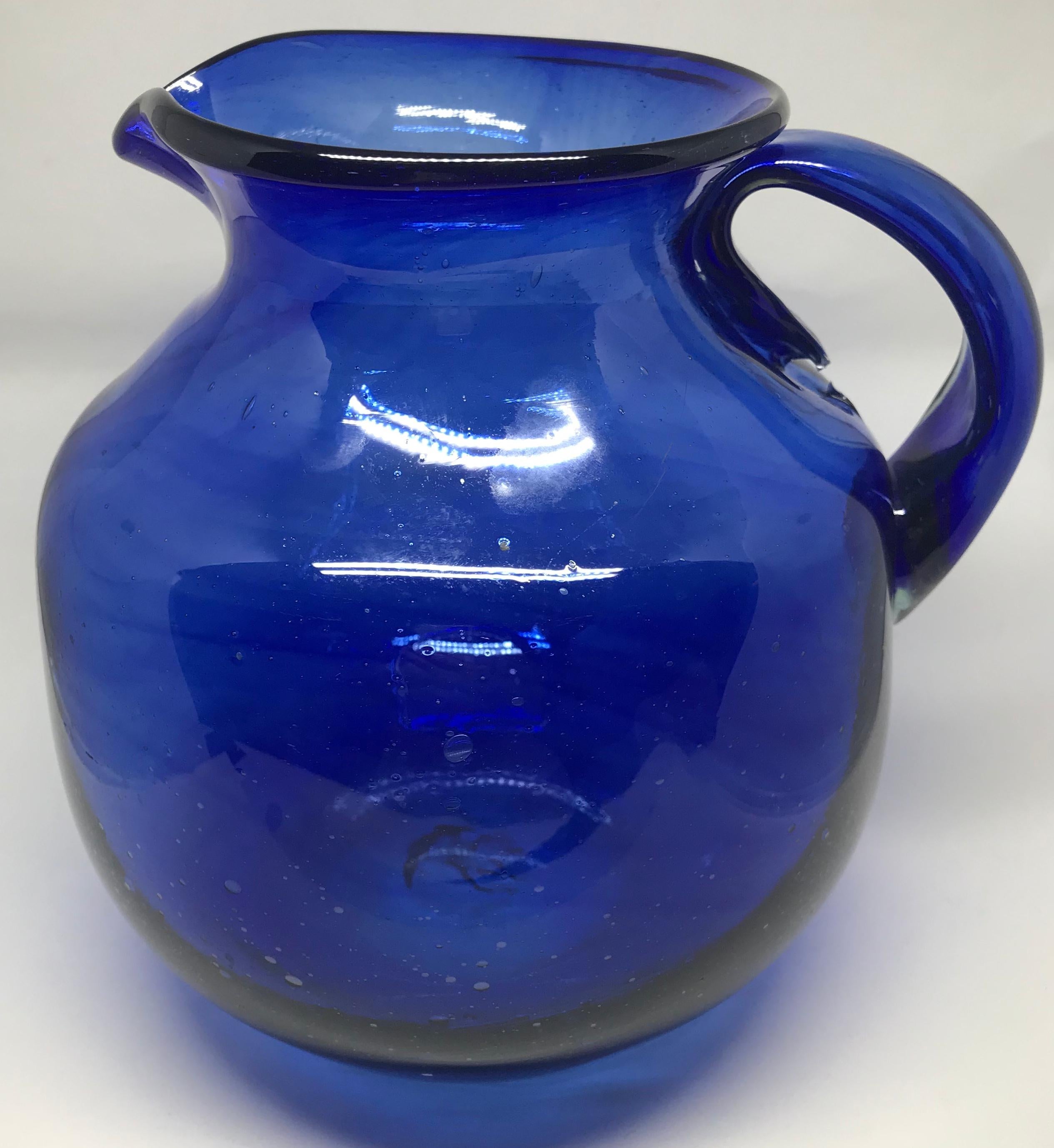 Cobalt blue glass pitcher. Rich cobalt blue three quart hand blown seeded glass pitcher or vase. American, 20th century. 
Dimensions: 8
