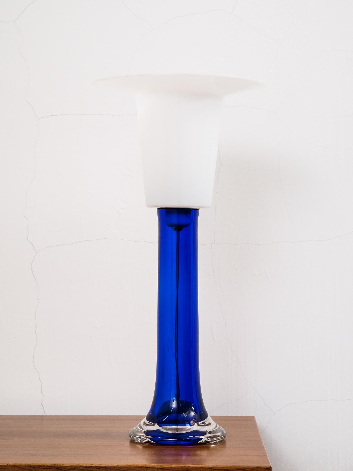 Grande lampe de table en verre bleu cobalt des années 1970 par Luxus Vittsjö, fabriquée en Suède. La partie supérieure est en plastique blanc.

Douille E27.