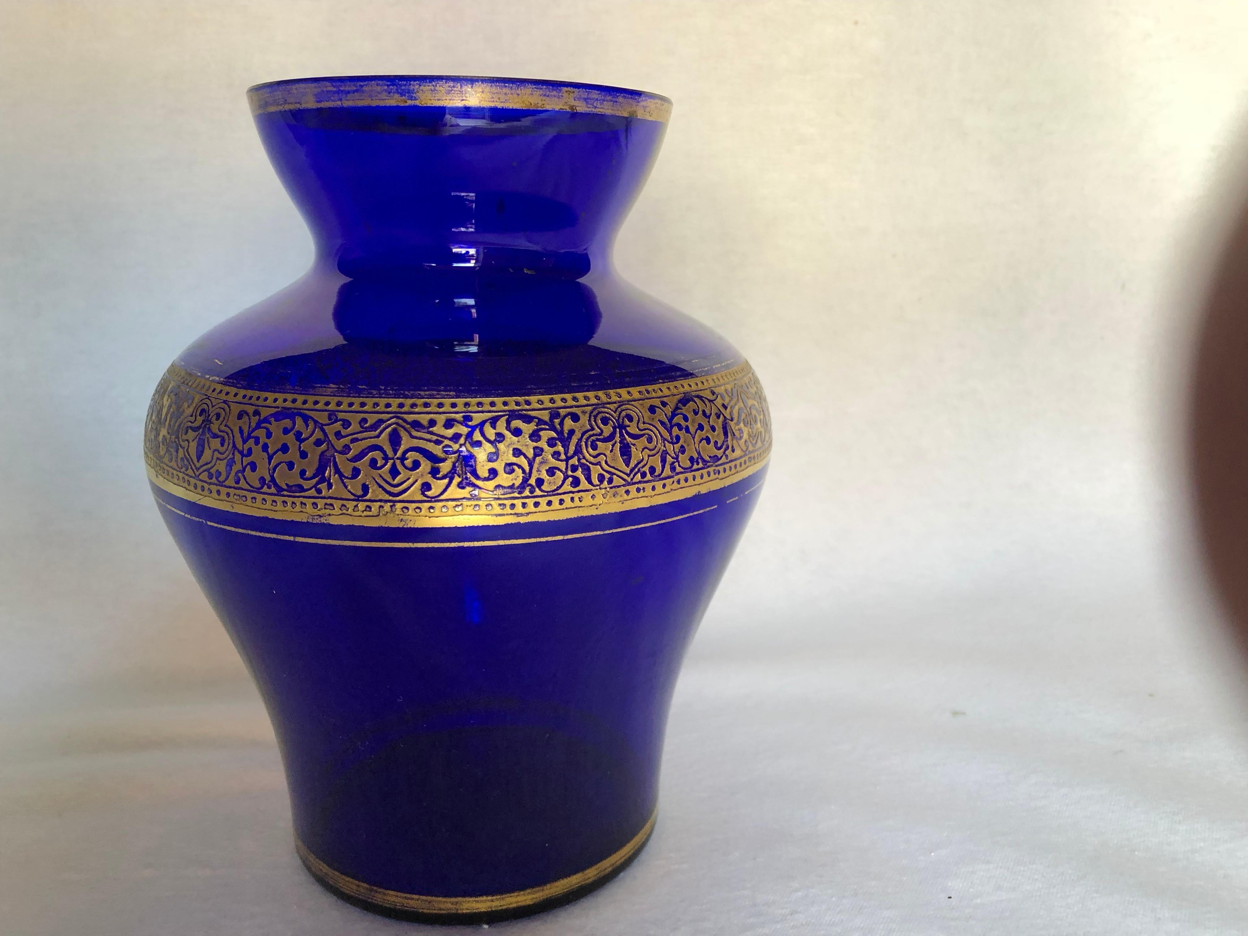 This beautiful vase was made in Germany of cobalt blue glass and is embellished with elaborate gold trim. No cracks or chips. Some gold loss.