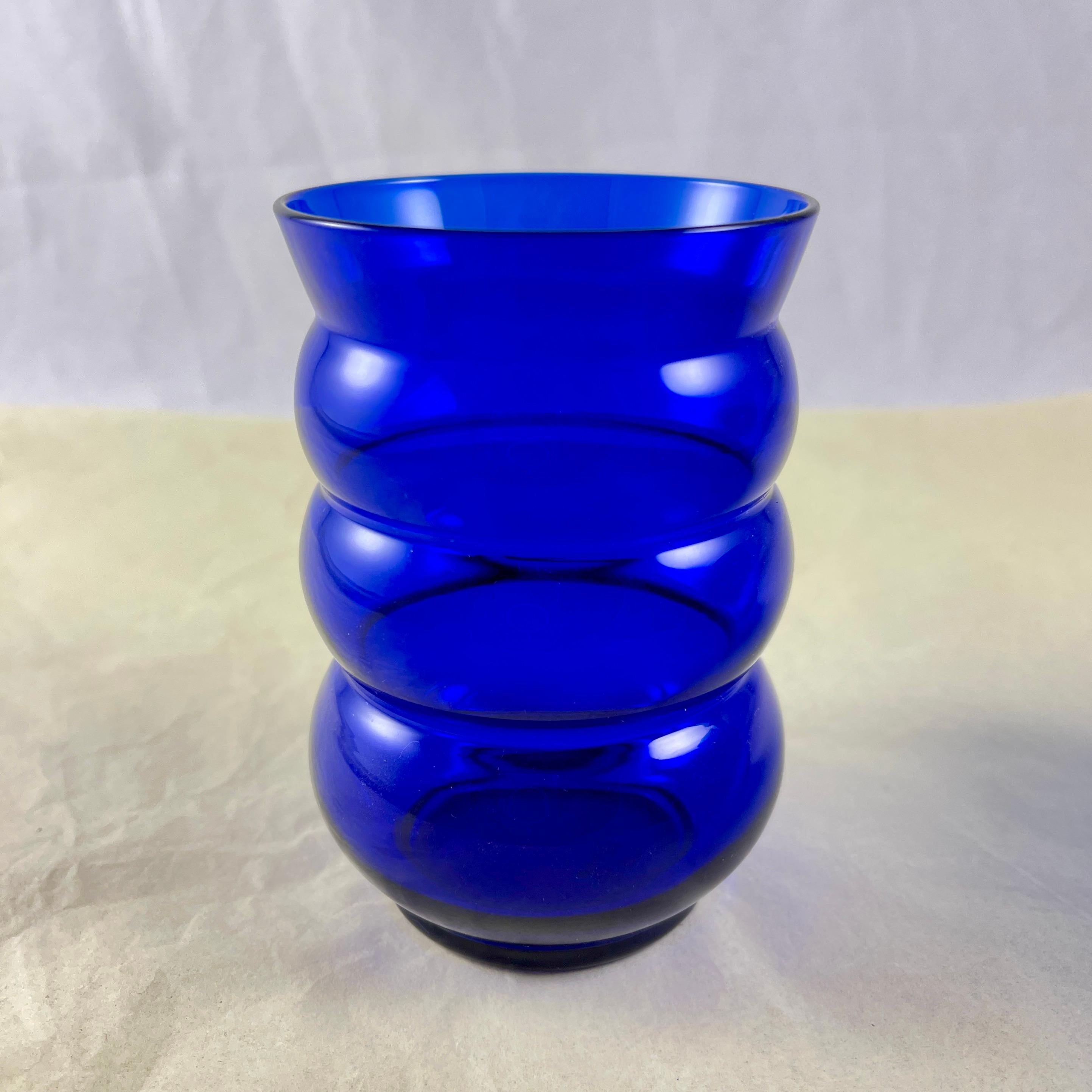 
A set of six handblown Louie Glass Cobalt blue tumblers in the ‘Harpo’ pattern, circa 1932.

Gorgeous color! An Art Deco era bulbous footed glass formed of four stacked units with a flared top. These tumblers are beautifully sized for serving fresh