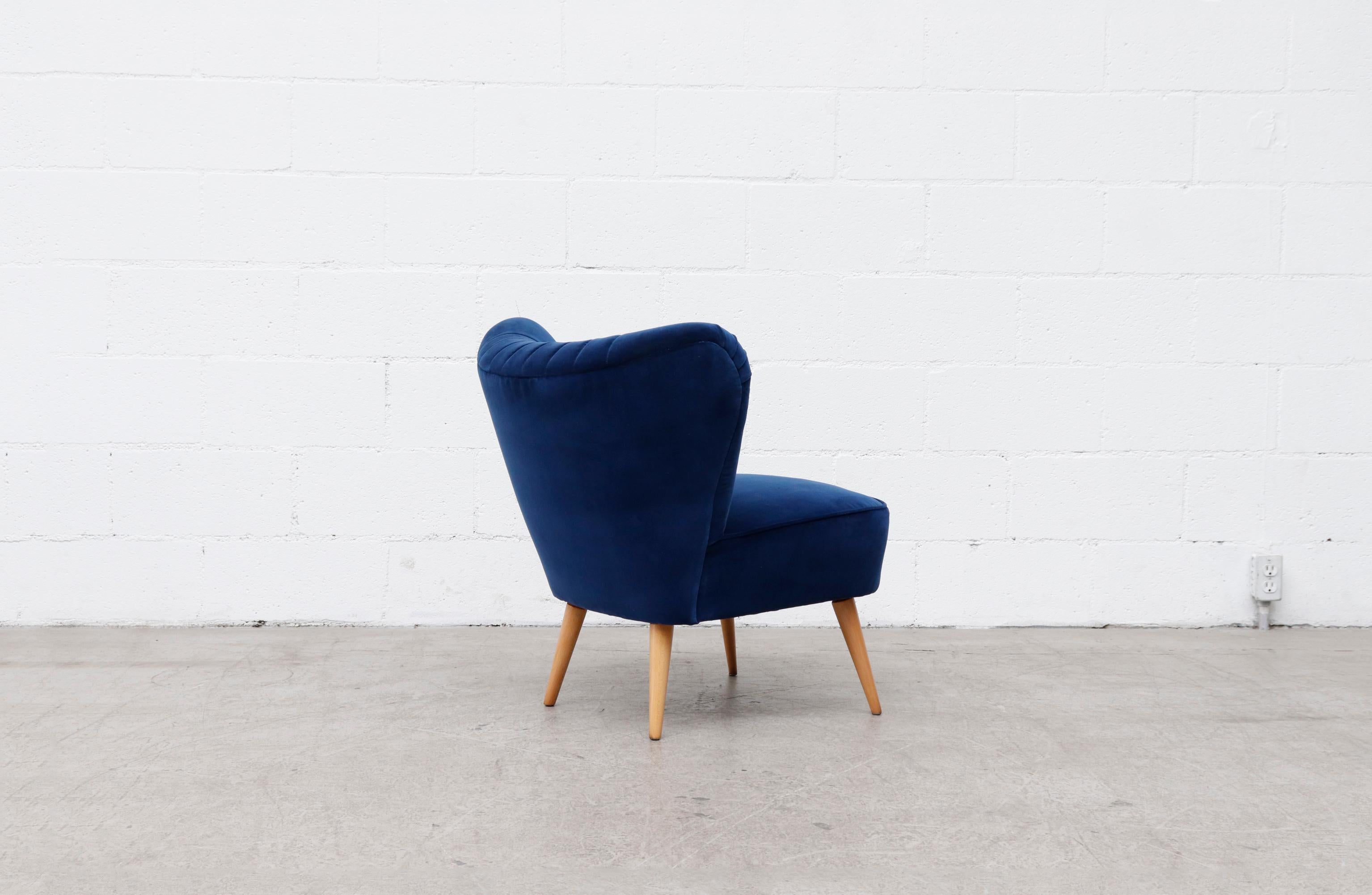 Stunning Theo Ruth style armless lounge chair in newly re-upholstered cobalt blue velvet with linear tufting and lightly refinished tapered legs.