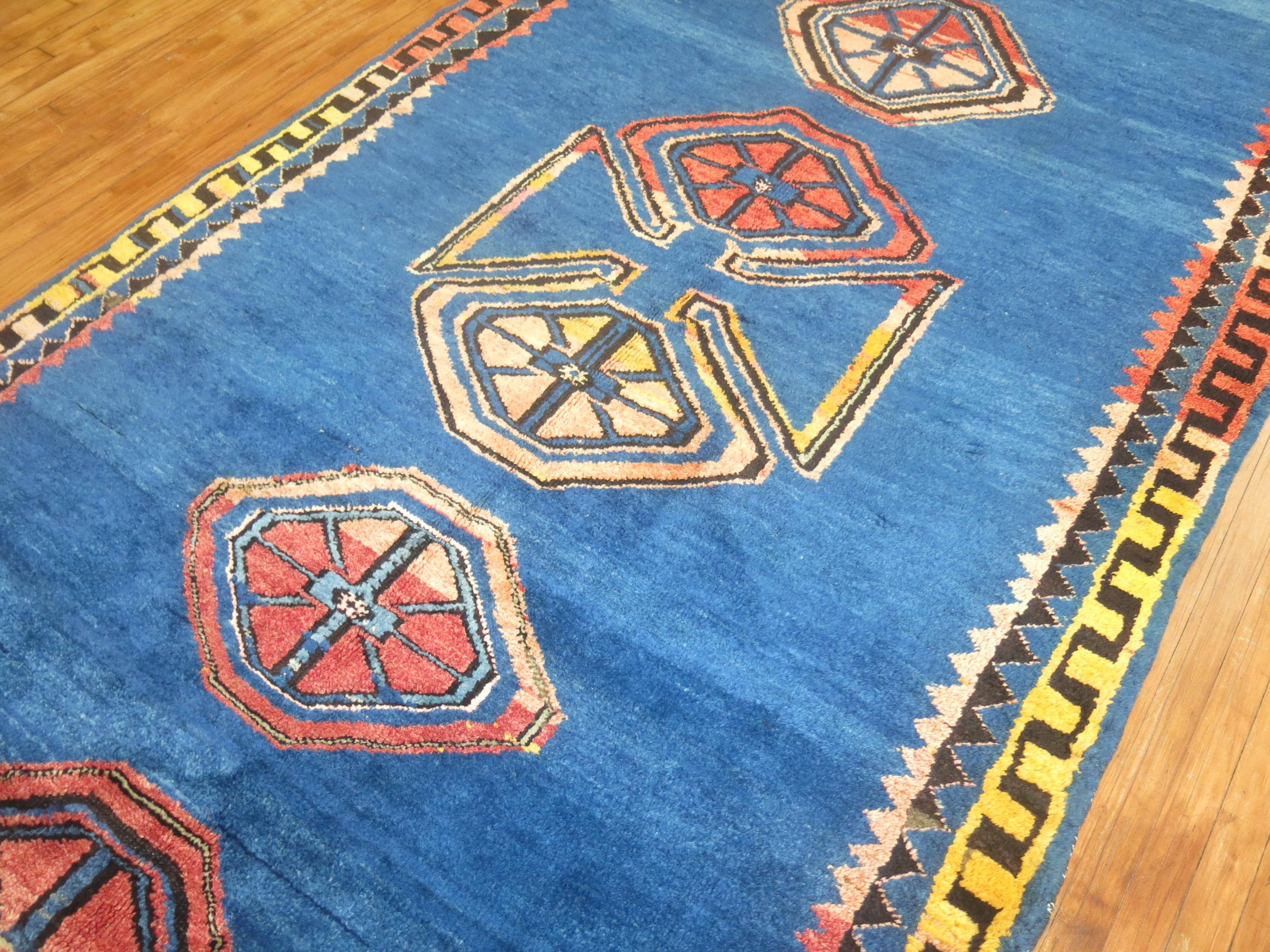 One of a kind mid-20th century handwoven Turkish rug with a folksy open palette design on a cobalt blue background. The blue abrashes found in the field( abrash are natural color variations found in some vintage and antique rugs) are common in