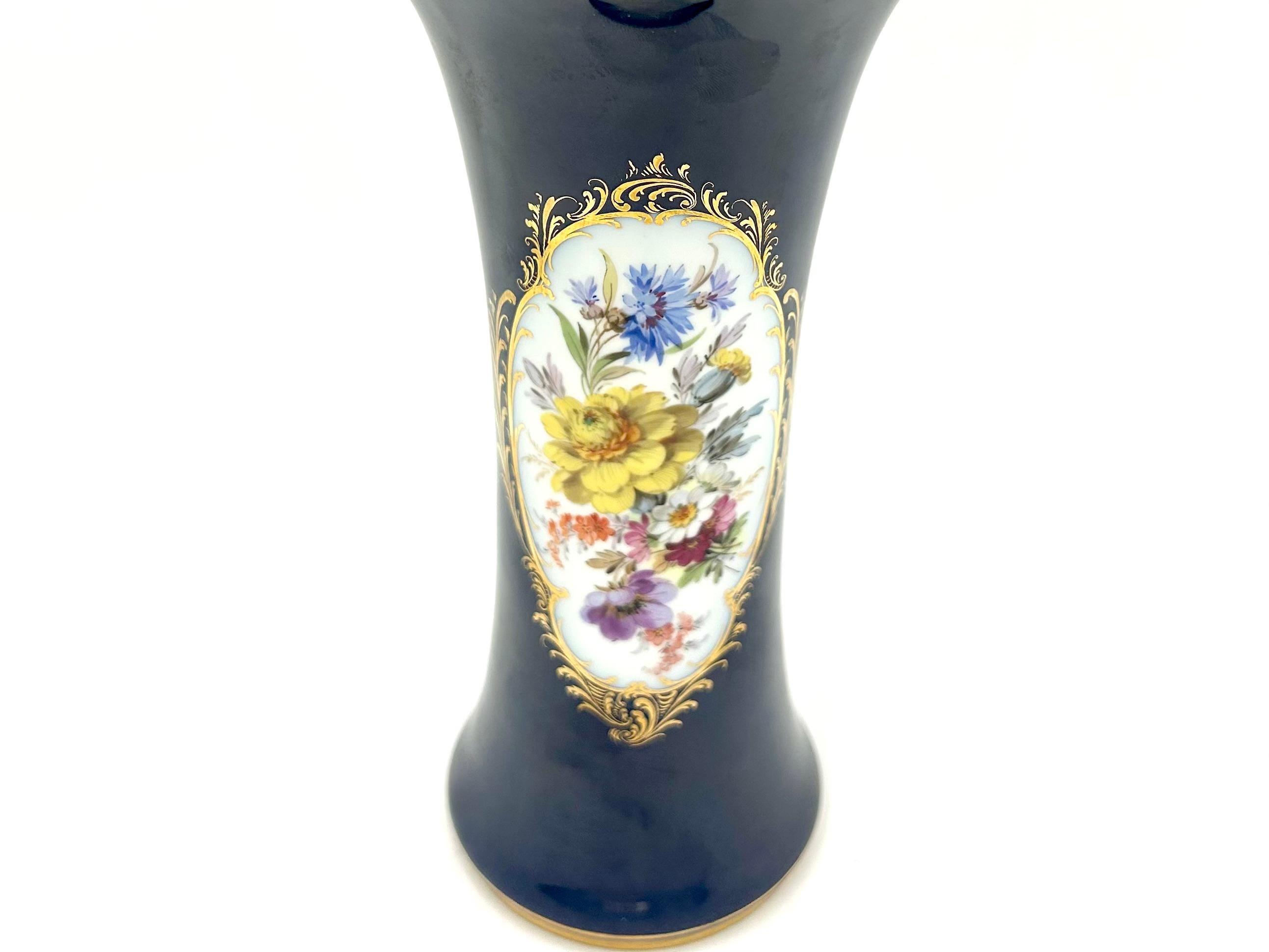 A cobalt vase produced by the excellent German factory Meissen.
White porcelain decorated with a floral motif on a cobalt background and gilding on the edge of the mouth.
The vase was produced around 1964. 
Very good condition without