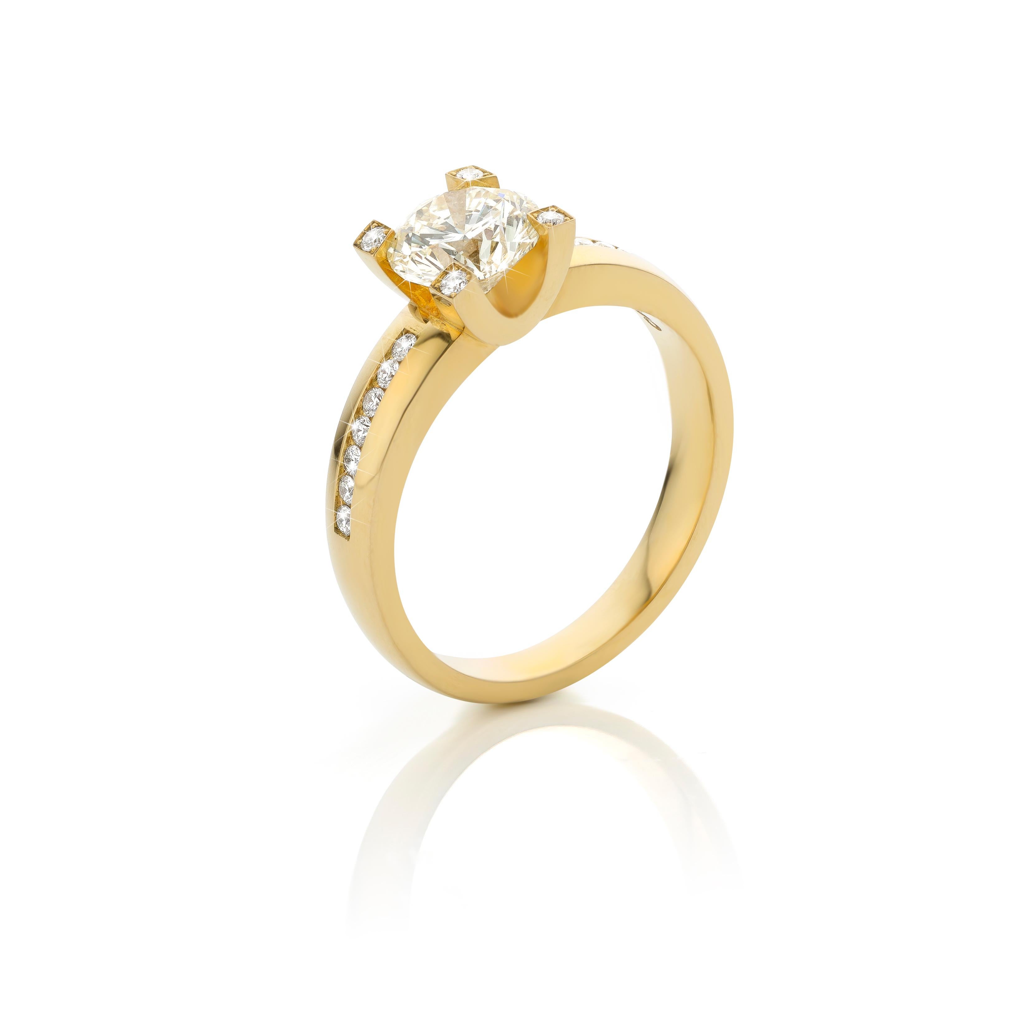 This is an 18 Carat yellow gold ring, with a beautiful and natural light yellow 1,27 ct. Brilliant-cut Diamond. In the claw of the setting and in the band of the ring are 18 x 0,01 ct. Brilliant-cut Diamonds. A beautiful piece for everyone who is