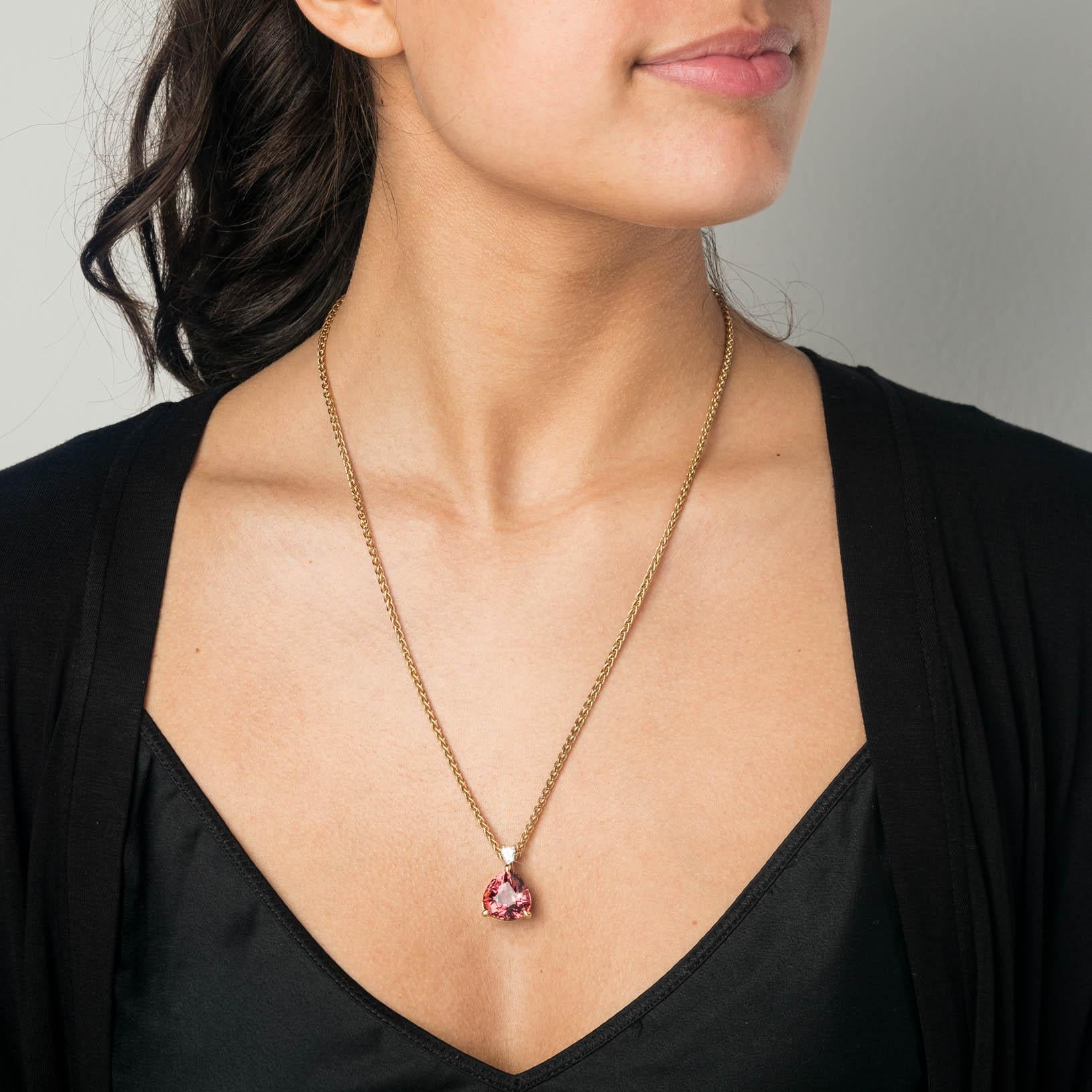 This is a 18 Carat yellow gold pendant with a Tourmaline and Diamonds. The pendant is made with a unique pure pink 14 Carat pear-cut Tourmaline, combined with a big claw setting and refined band with 22 pavé Diamonds. In the opposite direction, a
