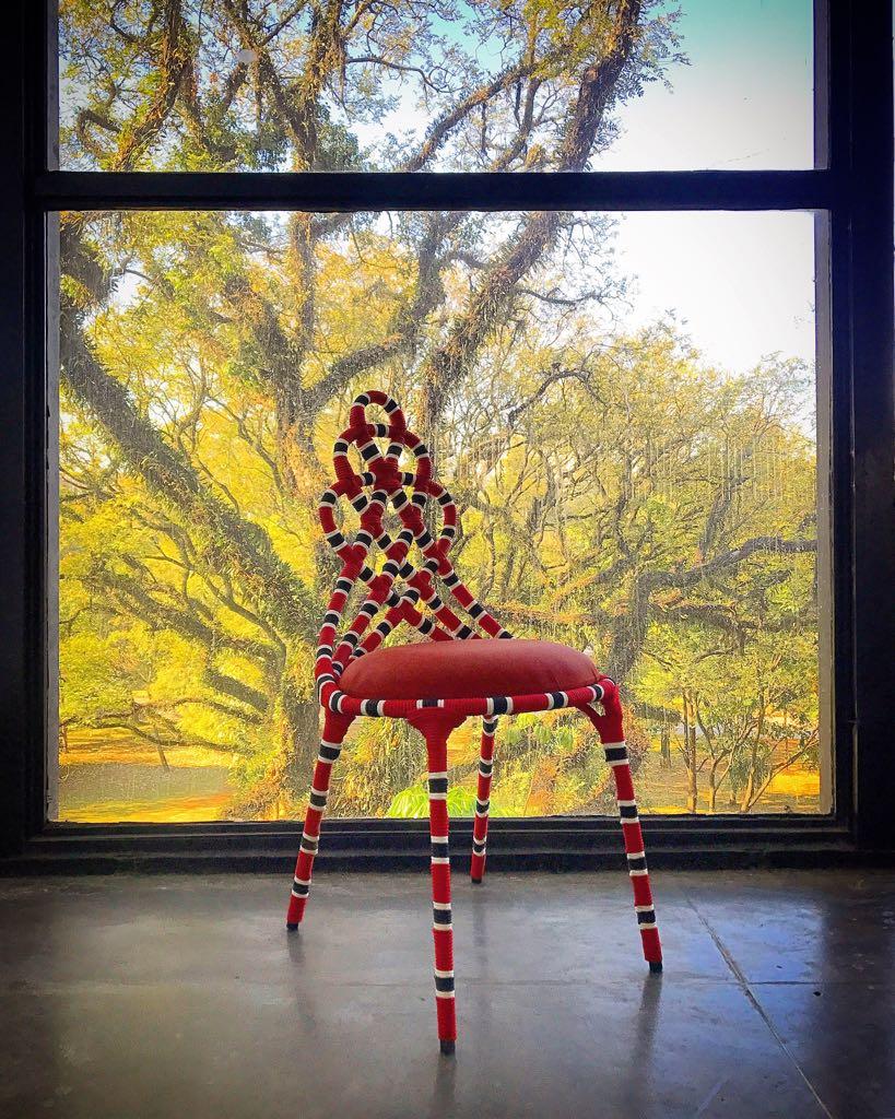 Exoticism ripples in the contours and colors of this handmade chair's contemporary design. It is the hallmark of the cobra coral chair that takes its seat in the daring and provocative design. The stainless steel structure bows to the hypnotic