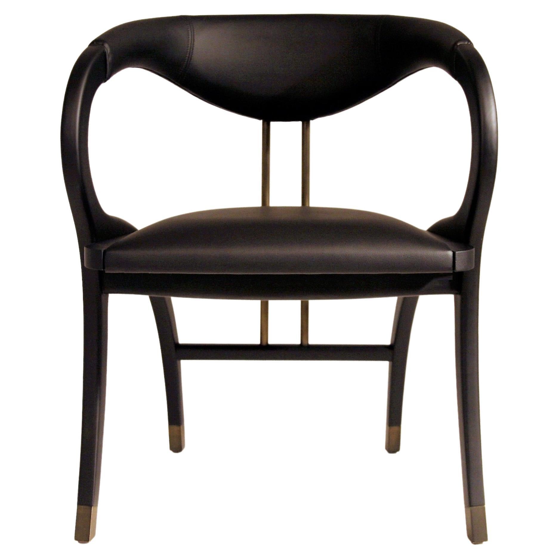 The Cobra chair features extraordinary design with curved back legs that form part of the armrests and back support in a continuous silhouette.
Handcrafted of solid oak in ebony finish and bronzed metal.
Upholstered seat and backrest in genuine