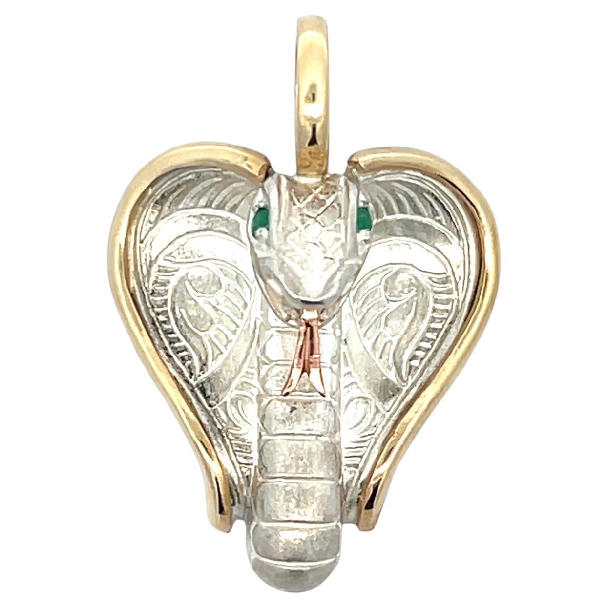 This exquisite cobra pendant is a true statement piece, meticulously crafted with a blend of 14k pink and yellow gold accents, complemented by sterling silver for a striking contrast. The serpent's hypnotic gaze is brought to life with faceted