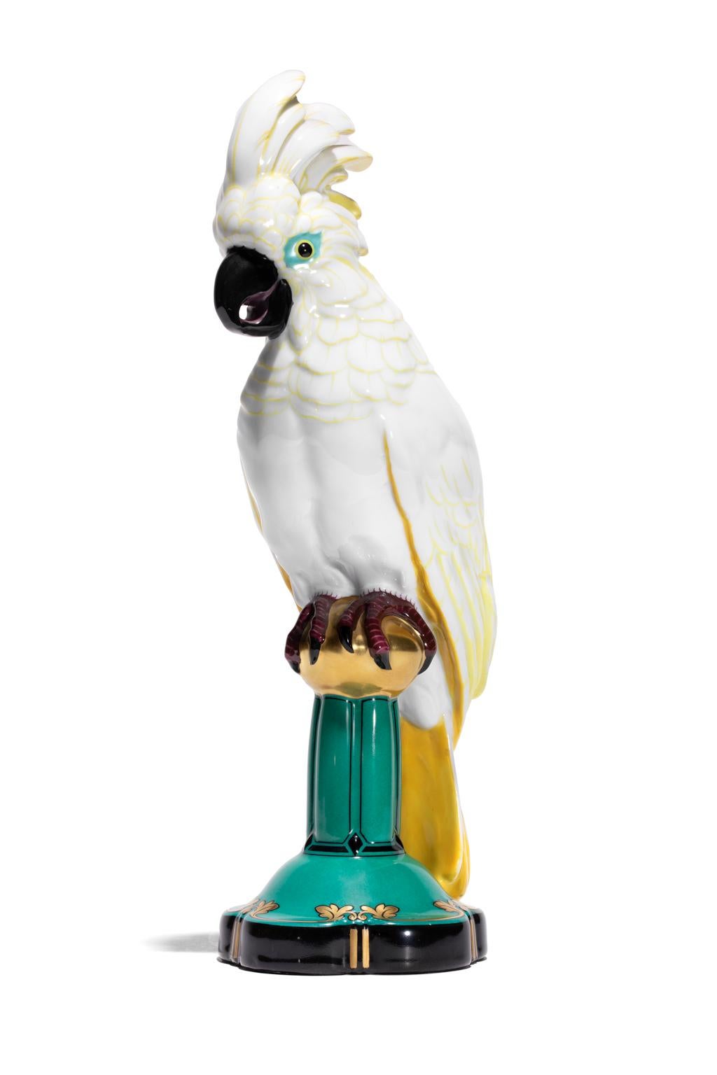 Cockatoo's with their glorious crown of plumage think they own the world and this one certainly does. It sits with royal dignity upon its lusciously painted Veridian and Gold glazed column. An exquisite Hutschenreuther-Selb porcelain that is over
