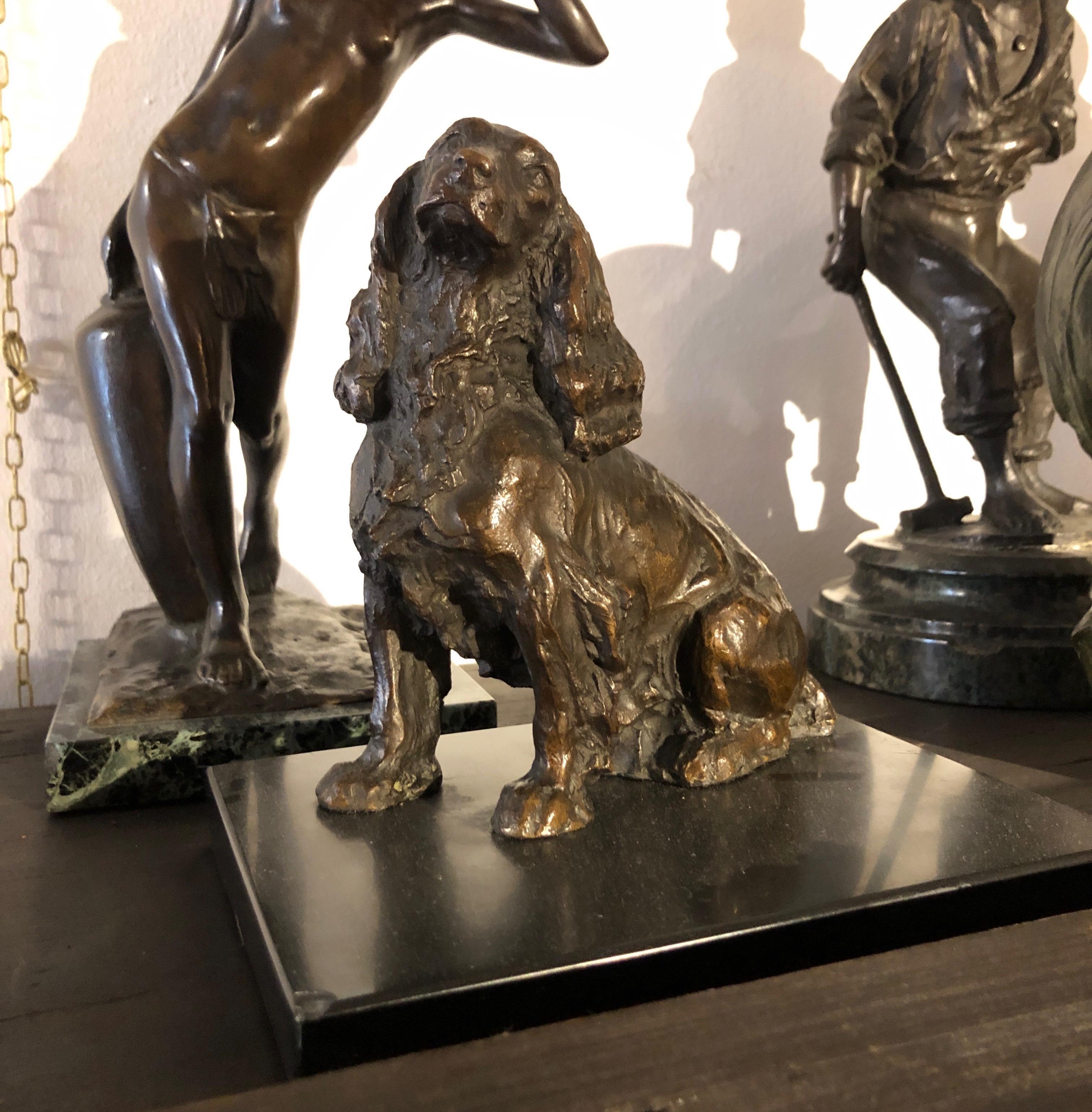 Scultura italiana di cane in bronzo, firmata e datata Leonardo Secchi 1942, raffigurante un Cocker Spaniel seduto. La fusione di bronzo  in terra poggia su base in marmo nero raffigurante un cocker seduto. La figura animalier è in ottimo stato di