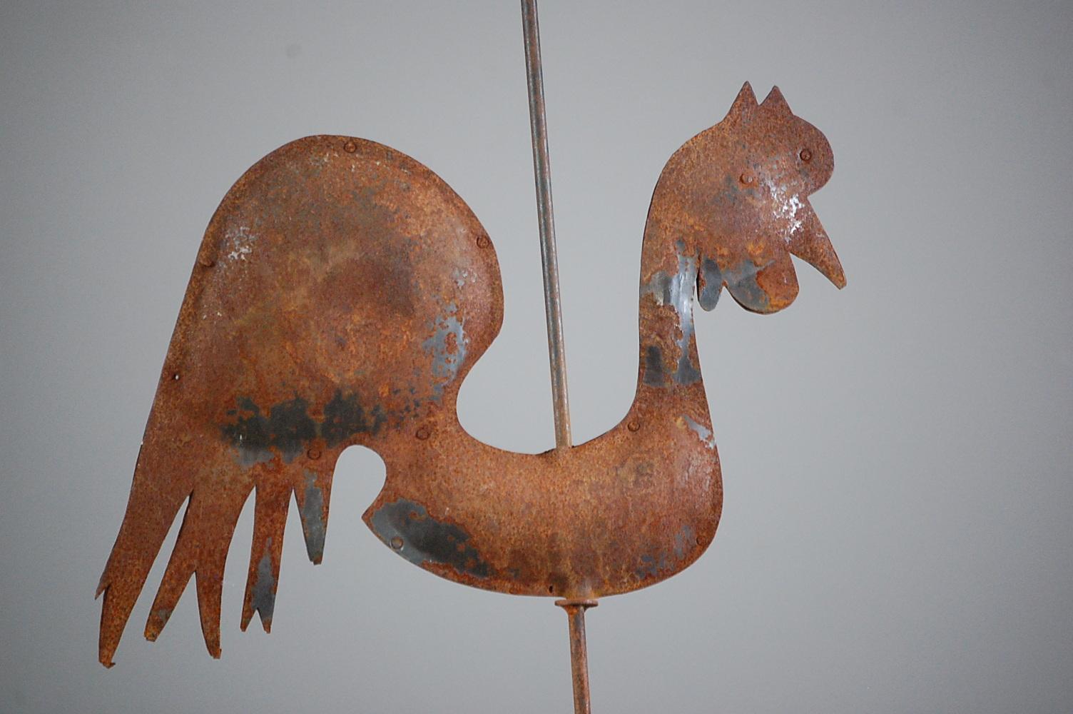 Jaunty expressive full bodied cockerel weathervane. Remnant paint and oxidised surface. original mounting pole. Mounted on weathered timber stand, France, circa 1950.