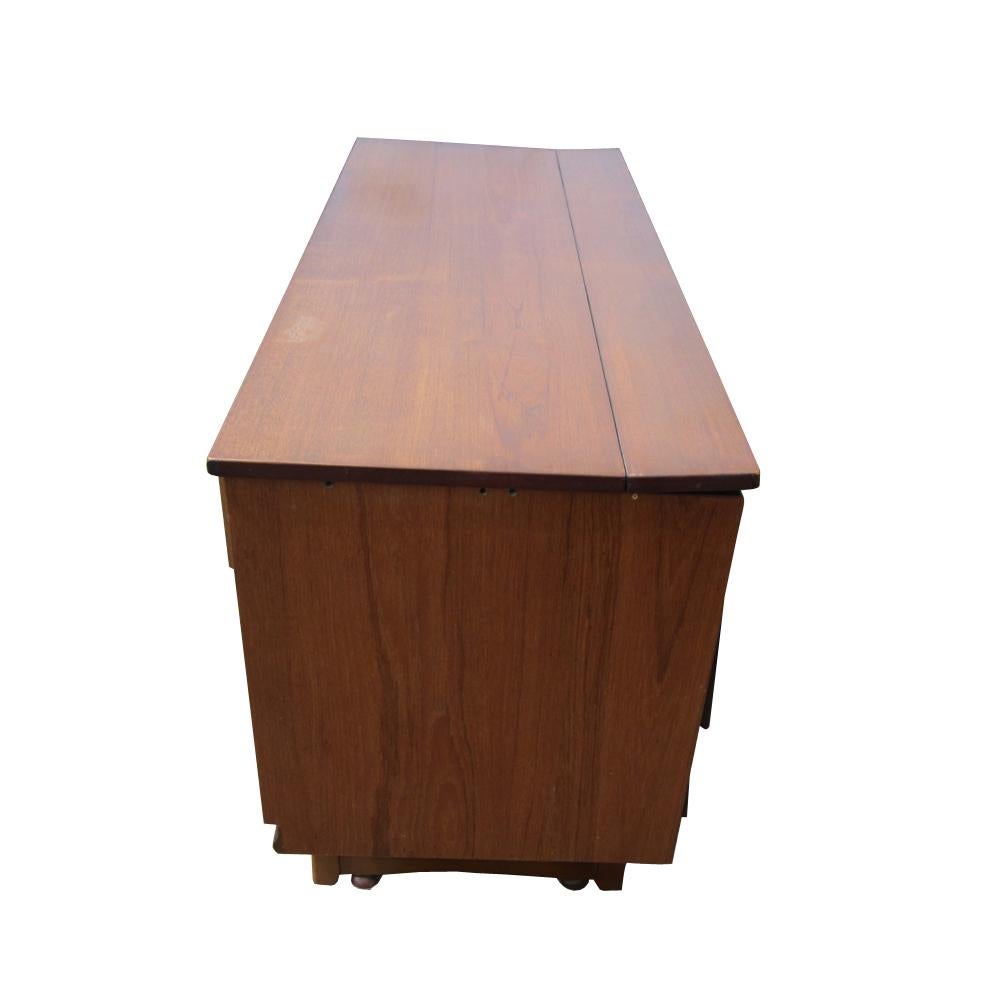 A Mid-Century Modern display cabinet or bar with a credenza. This cocktail cabinet has a detachable display top, two drawers, two cabinets and a back that opens to a mini-bar.  Cabinet can also serve as a room divider as it opens on both sides.