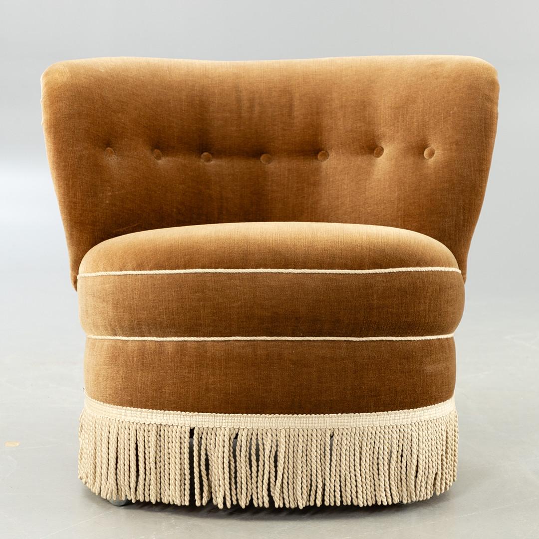 The beige velvet fringed Cocktail armchair is a true treasure from the 1940s that has stood the test of time with elegance and style. This iconic seat, in its original and perfectly preserved condition, evokes the opulence and glamor of a bygone