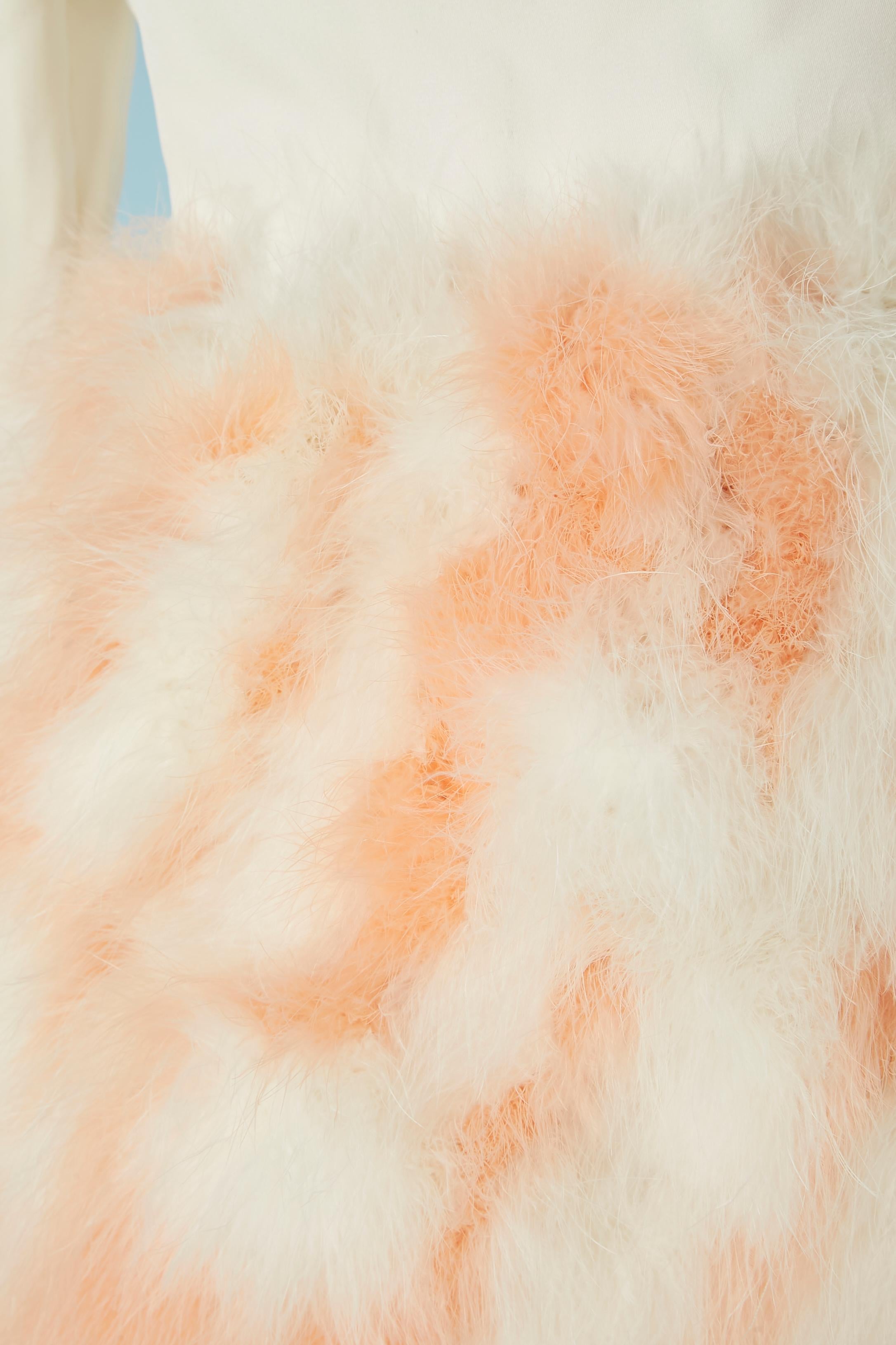 Abito da cocktail in rayon bianco sporco e piume bianche e rosa. Fodera in acetato. Le piume sono cucite su una base di organza Zip e si chiudono a scatto al centro della schiena. Cintura ad anello 
TAGLIA M 
