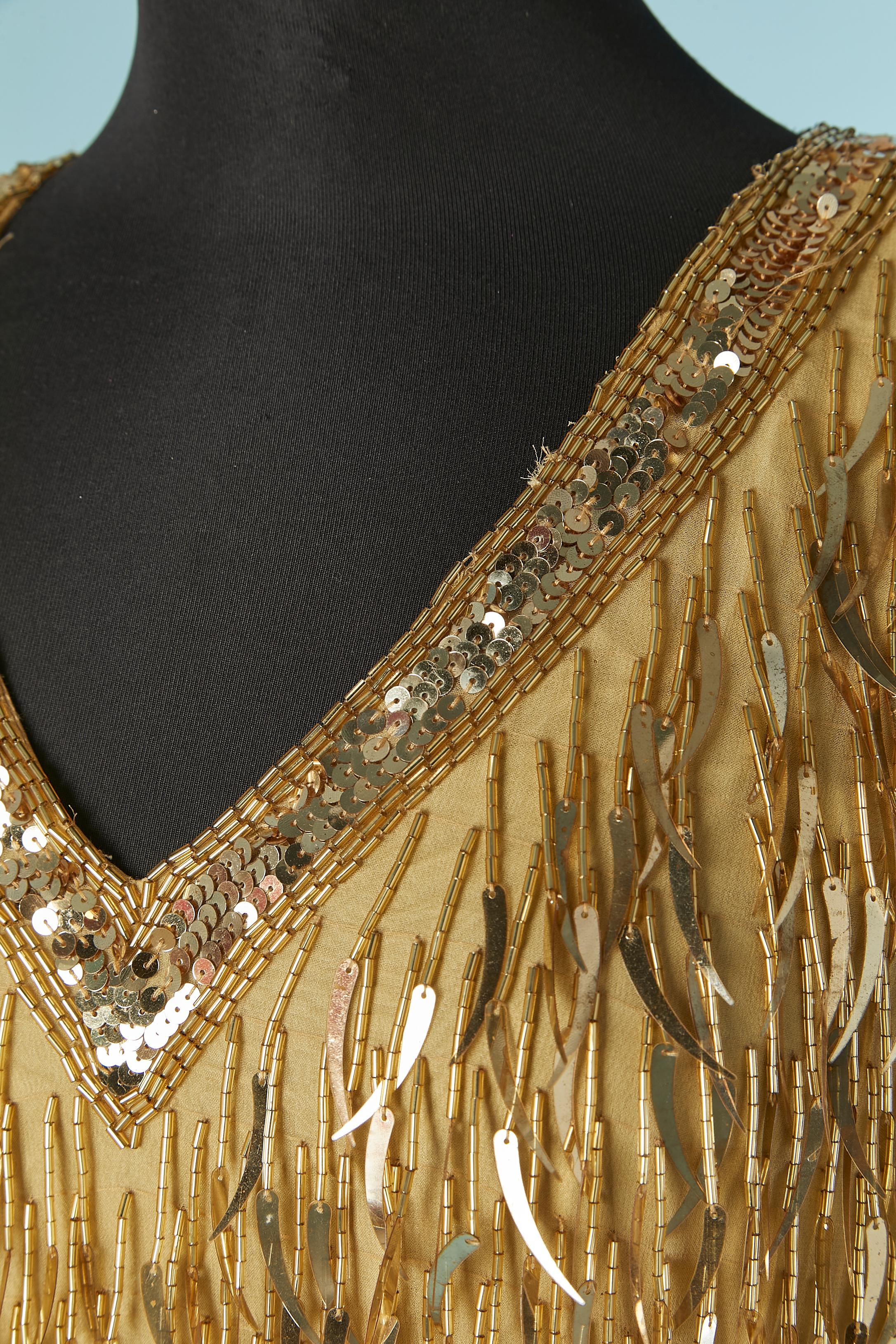 Cocktail dress made of gold sequin and beads fringes on a silk base. Rayon lining. 
Shoulder pad. Zip and hook&eye closure on the middle back. Split on the middle back, lenght = 15cm
SIZE 8 (US) M 