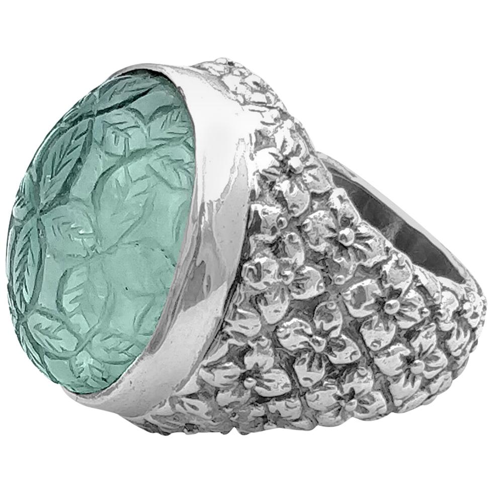 • Stephen Dweck Carventurous Collection 
• 925 Sterling Silver
• 0.95” X 0.88”

This gorgeous Carved Oval Rock Crystal over aqua Mother of Pearl Cocktail Ring is truly alluring in nature. The beautiful combination of natural rock crystal and aqua