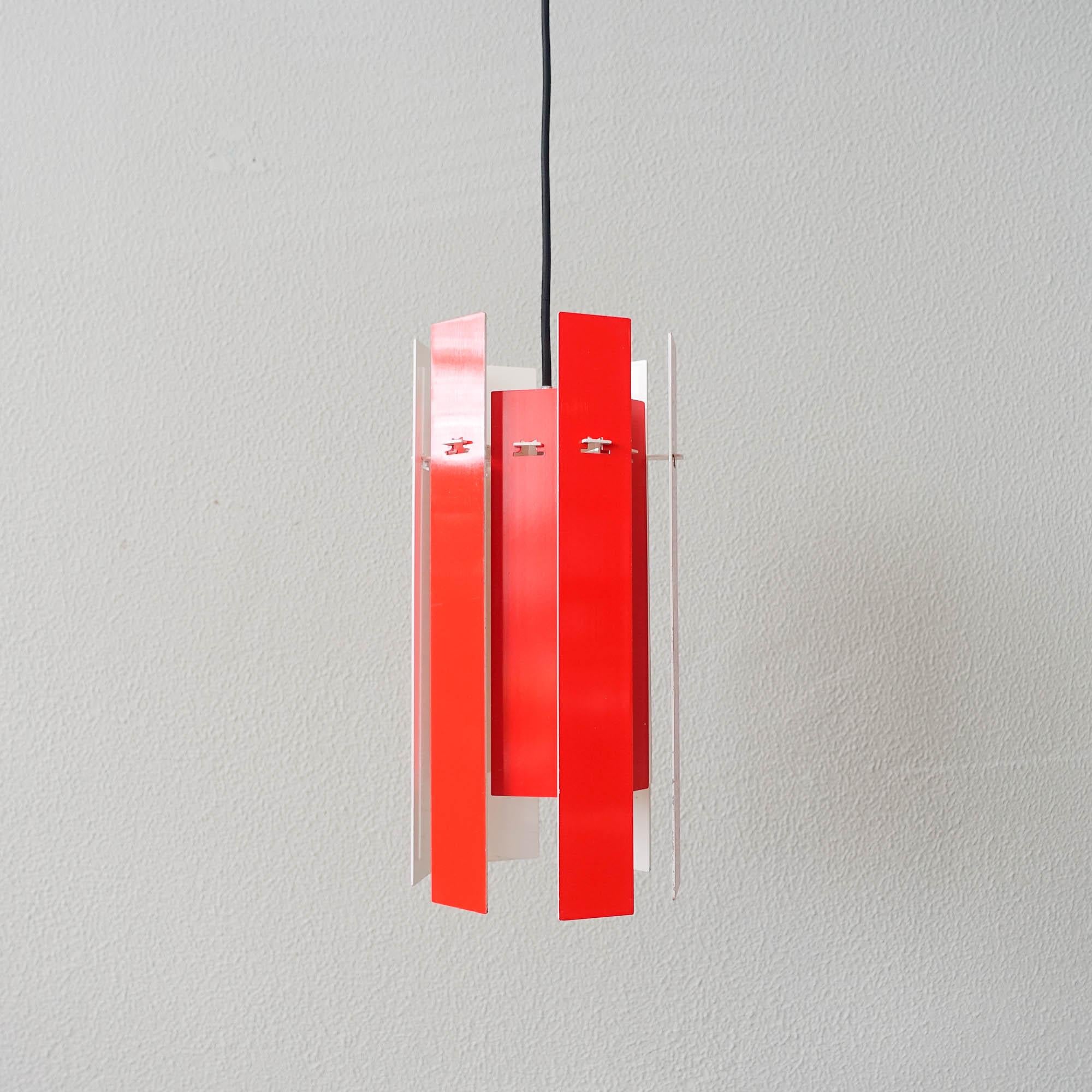 This pendant lamp, model Cocktail, was designed by Henning Rehhof in 1970 for Fog & Mørup, Denmark. The lamp has twelve metal strips, six longer ones and six shorter painted red on one side and white on the other. The strips are hung for a circular