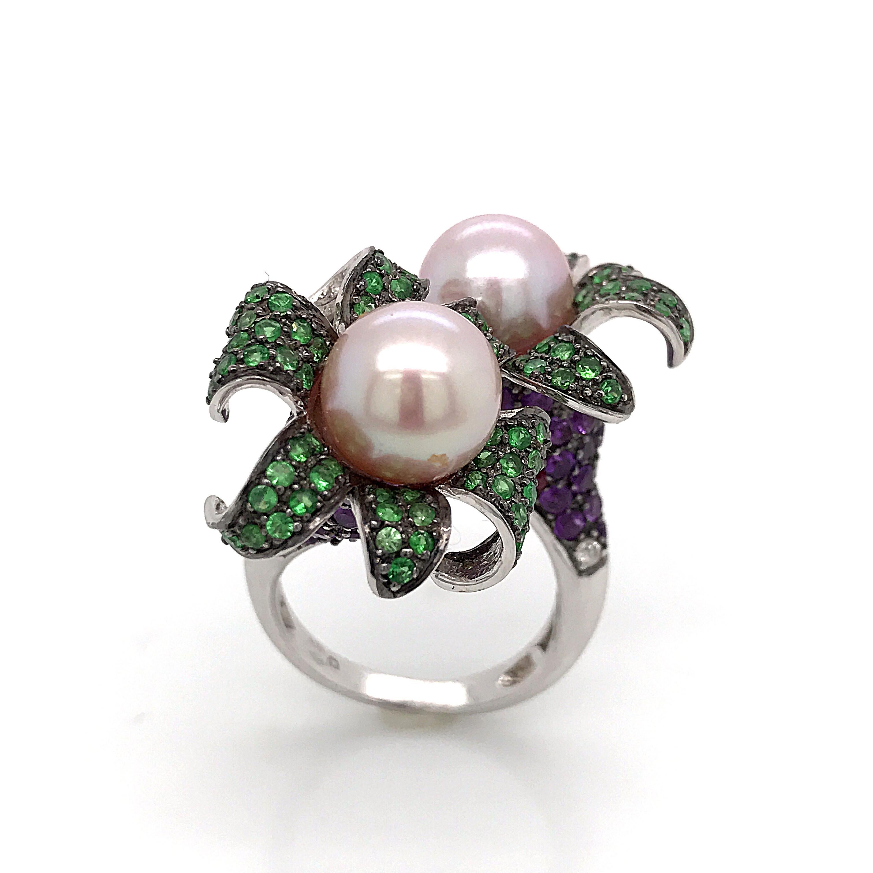 Discover this remarkable artistic ring, a true masterpiece of jewellery, harmoniously combining the brilliance of emerald, amethyst, diamond and ruby cultured pearls with the timeless elegance of the 18-carat white gold setting. This exceptional