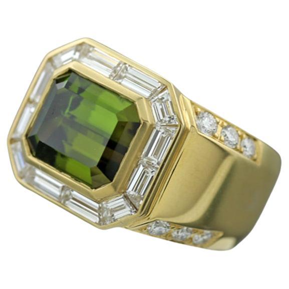 A remarkable ring featuring a green tourmaline, also called verdelithe,  in an octagonal cut, weighing approximately 4.40 carats. The tourmaline is surrounded by seamlessly set diamonds in varied baguette cuts, totaling approximately 1.32 carats.