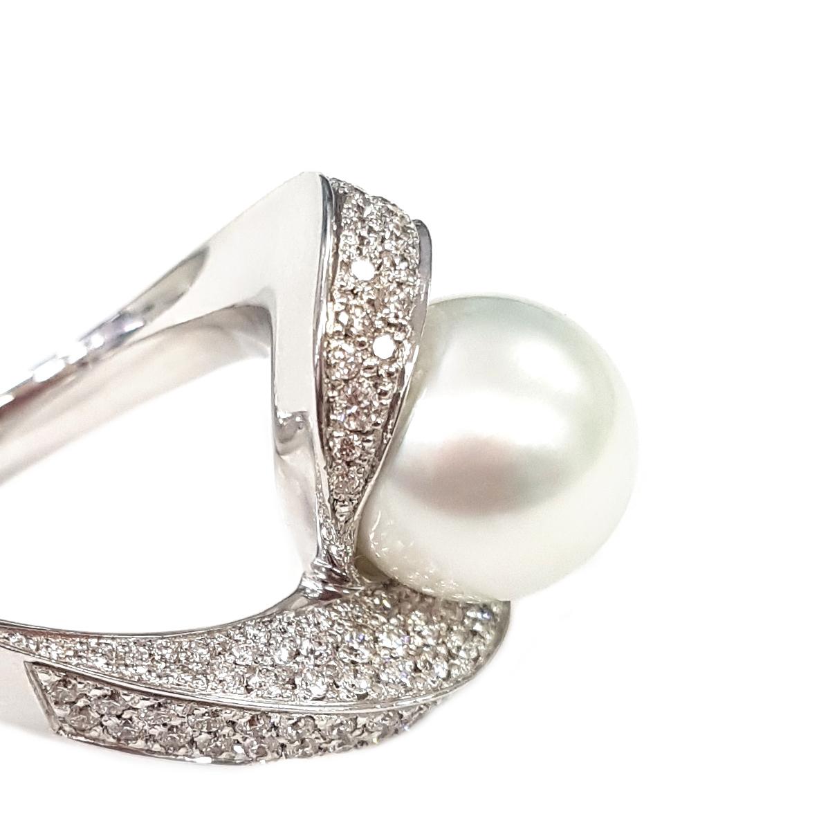 An elegant cocktail ring masterfully created entirely by hand from 18-karat white gold and featuring a 10-carat Australian pearl which appears to balance atop a pair of spiralling arms set with white diamonds totalling 1.14 carats. 

The top of the