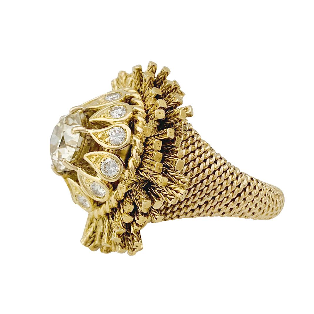 A 18K yellow gold Sterlé ring, centered with a round cut diamond; the surrounding of the center stone is made up of small closed-set brilliants in teardrop motifs; the whole is surrounded by a fringe of mobile chains when you move your