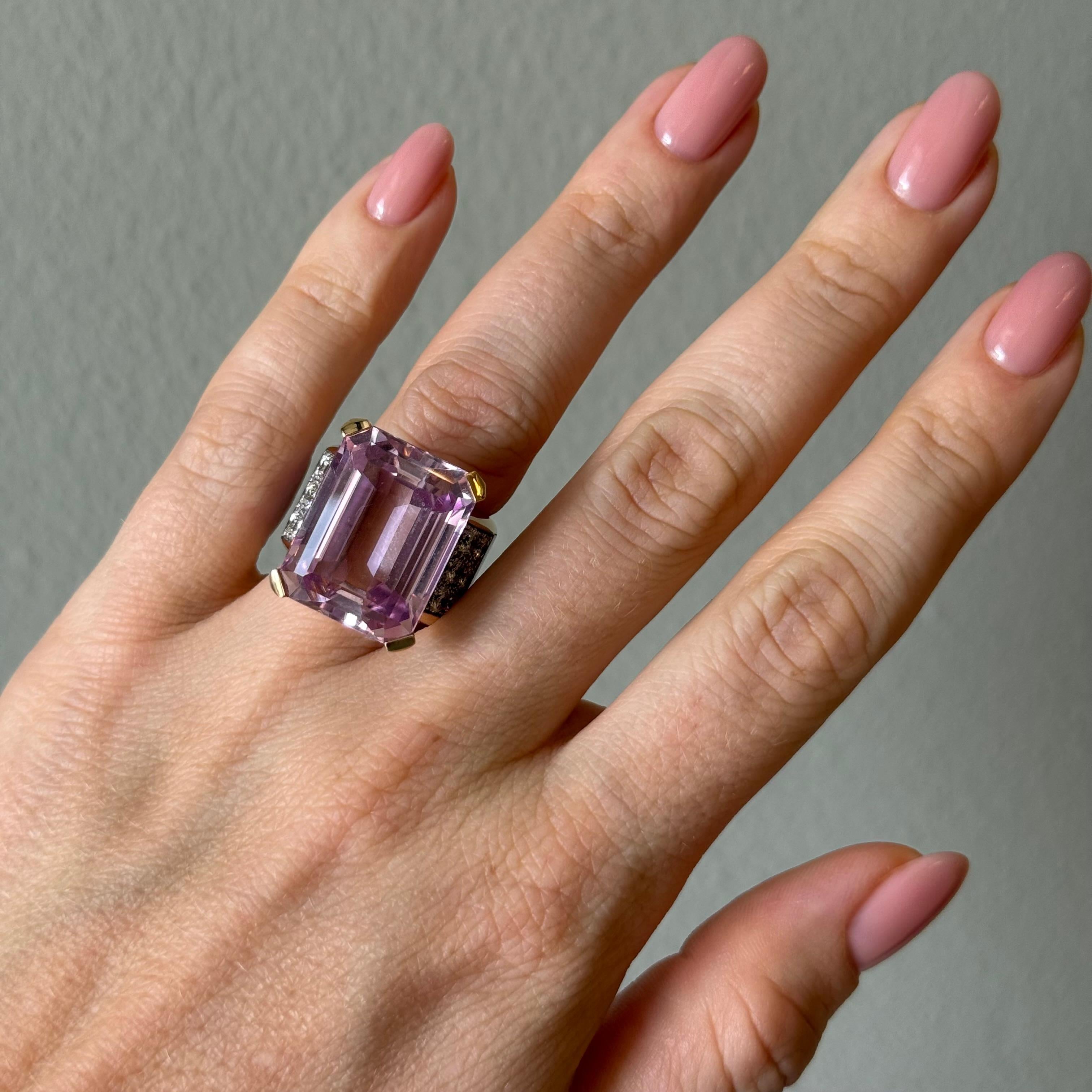 Dieser Ring aus 18-karätigem Gelbgold von Paul Binder ist ein auffälliger Blickfang. Er präsentiert einen atemberaubenden Kunzit im Smaragdschliff von ca. 25 Karat mit strahlender Klarheit und zartrosa Brillanz.
Flankiert von 18 funkelnden Diamanten