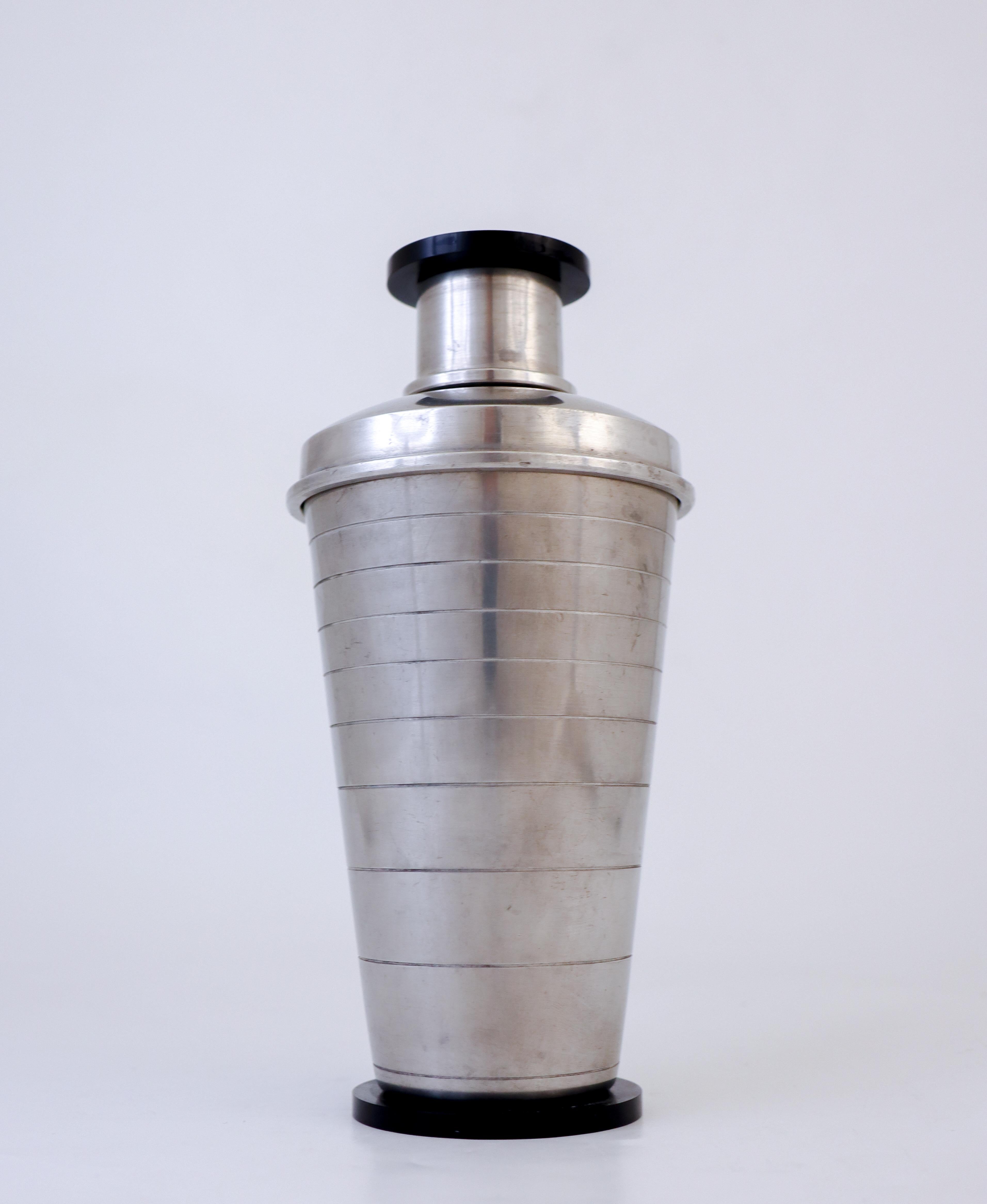 A stunning cocktail shaker designed by Carl-Einar Borgström at Ystad Metall, Sweden in 1930 in classic art deco. It is in excellent condition except from some minor scratches. It is made in metal with details in bakelite. The shaker is 21 cm tall