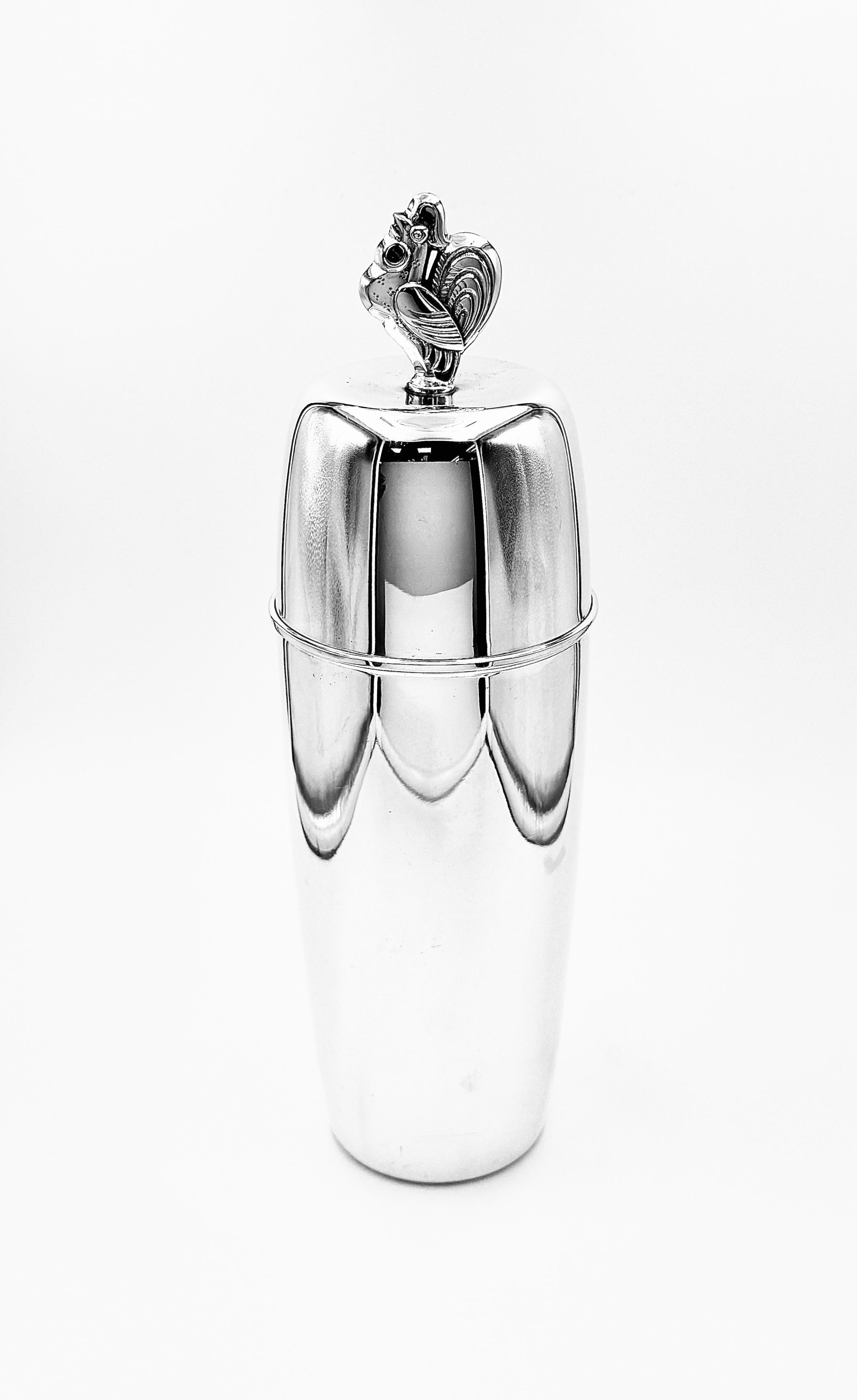 Silver-plated cocktail shaker of tapering form, topped with a finial cast as a rooster. The sleek, polished body and geometric lines reflect the elegance of the Art Deco period. 

Founded in the late 19th century, David-Andersen is a distinguished