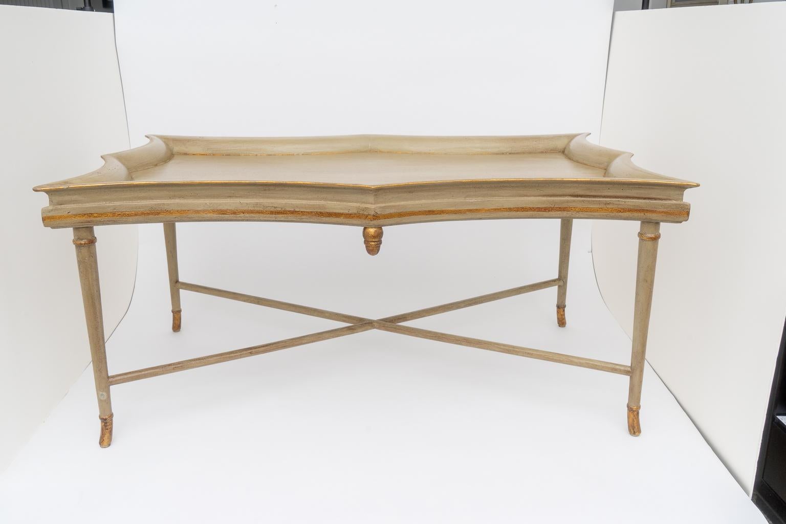 This stylish tray-table form cocktail table was acquired from a Palm Beach estate. The piece has a crackle finish, in a putty coloration with antique gold accents.