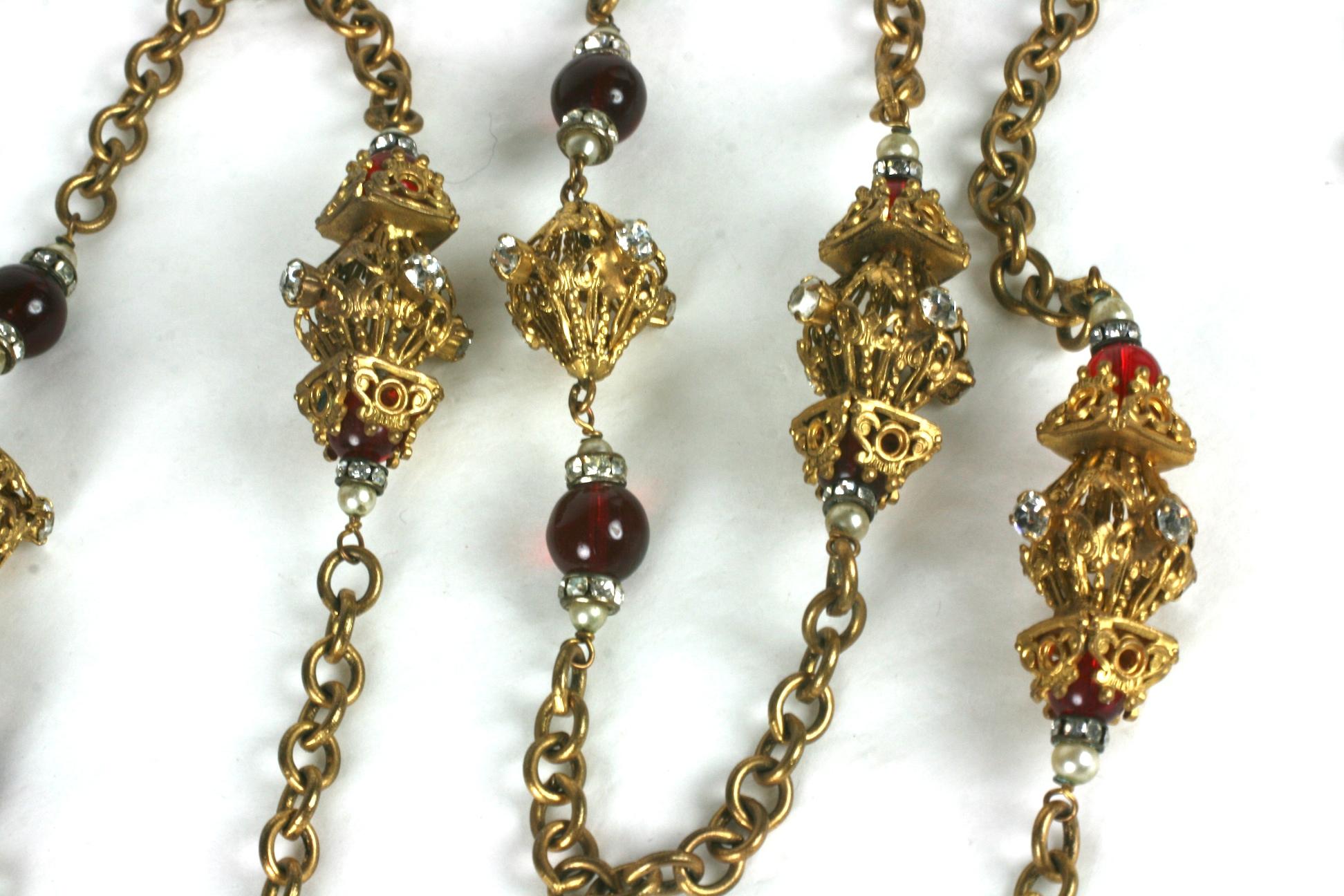 Sautoir dei primi anni di Coco Chanel realizzato da Robert Goossens di ispirazione rinascimentale, composto da perline in pate de verre color rubino intenso affiancate da rondelle di brillanti di cristallo e piccole perle finte. Ci sono stazioni a