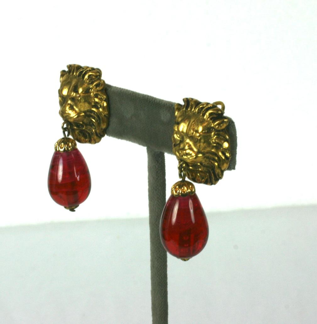 The most classic of earrings from Chanel with lions heads motifs . This is one of her favorite code motifs in textured and gilded bronze. Ruby Pate de verre pendant teardrops with clip back fittings. France circa 1960s.  Unsigned.
Excellent 