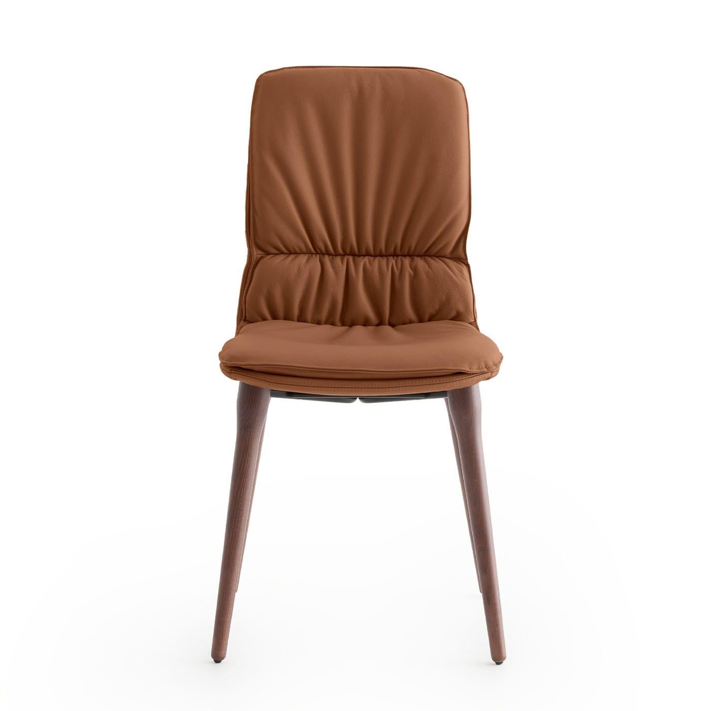 A sleek thermo-formed MDF shell sustained by tapered walnut-stained ash legs lends this chair its unmistakable modern character. Outstandingly luxurious yet restrained, it flaunts a precious cognac-hued leather cover - enriched with ripples in the