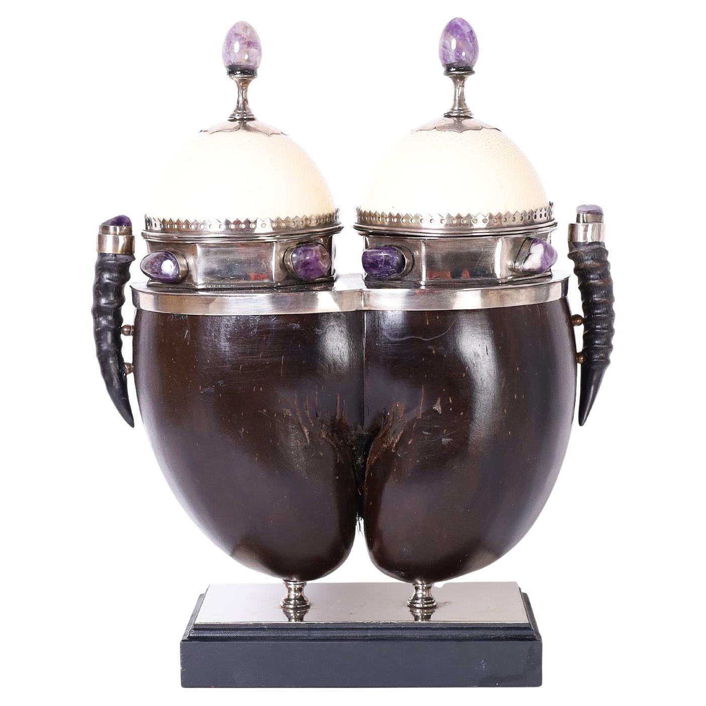 Rare and unusual tea caddy crafted from a coco de mer shell featuring amethyst stone handles and embellishments, ostrich egg tops with refined metal work, and antelope horn side handles. Stamped Redmile London under a lid.