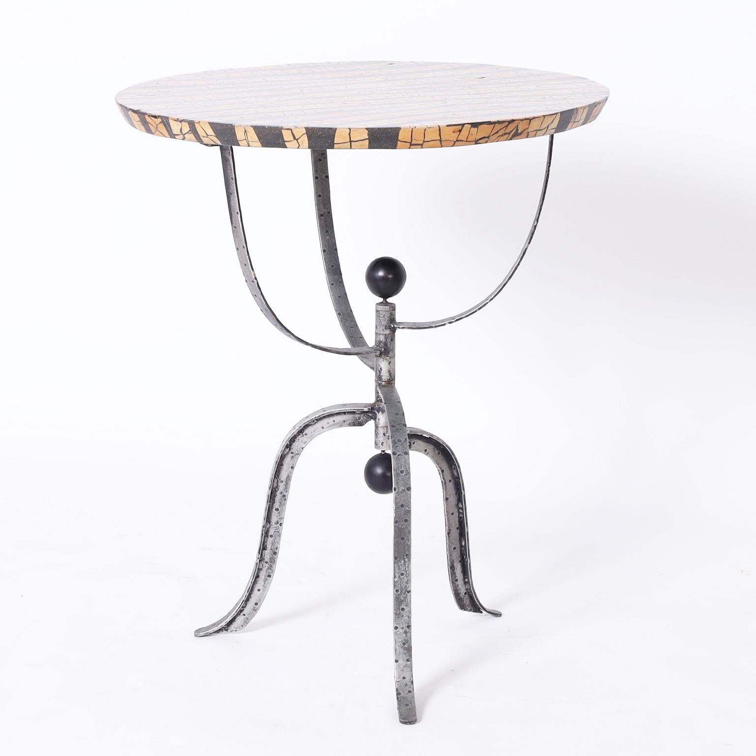 Ungewöhnlicher modernistischer Ständer oder Tisch mit einer runden Platte aus Kokosnussmosaik über einem handgeschmiedeten dreibeinigen Sockel im postmodernen Stil mit runden schwarzen Endstücken.