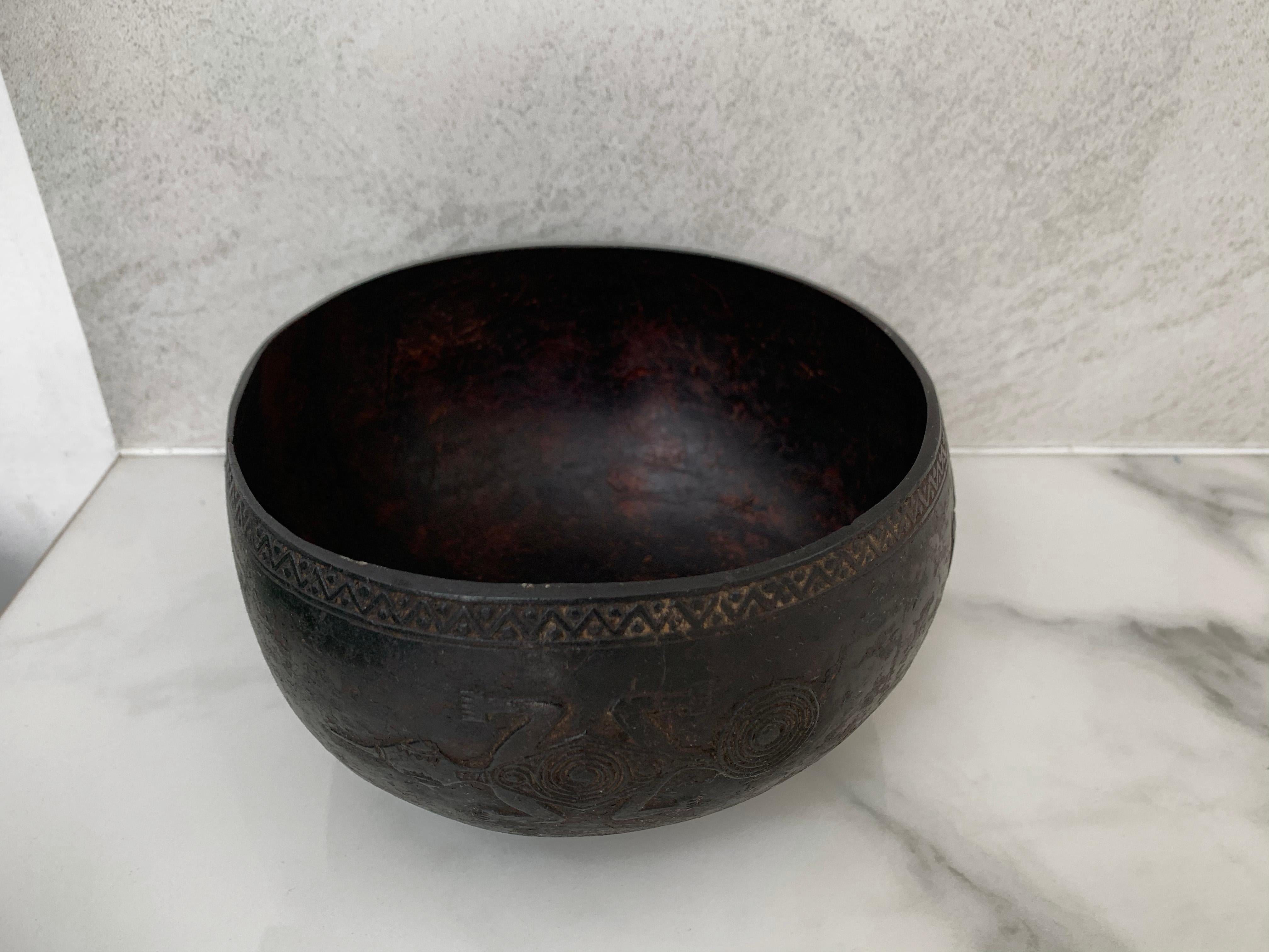 This hand crafted and tribal engraved bowl originates from Nias Island Indonesia. It features tribal motifs depicting reptile and human forms on its outter side as well as tribal motifs along the rim.
 