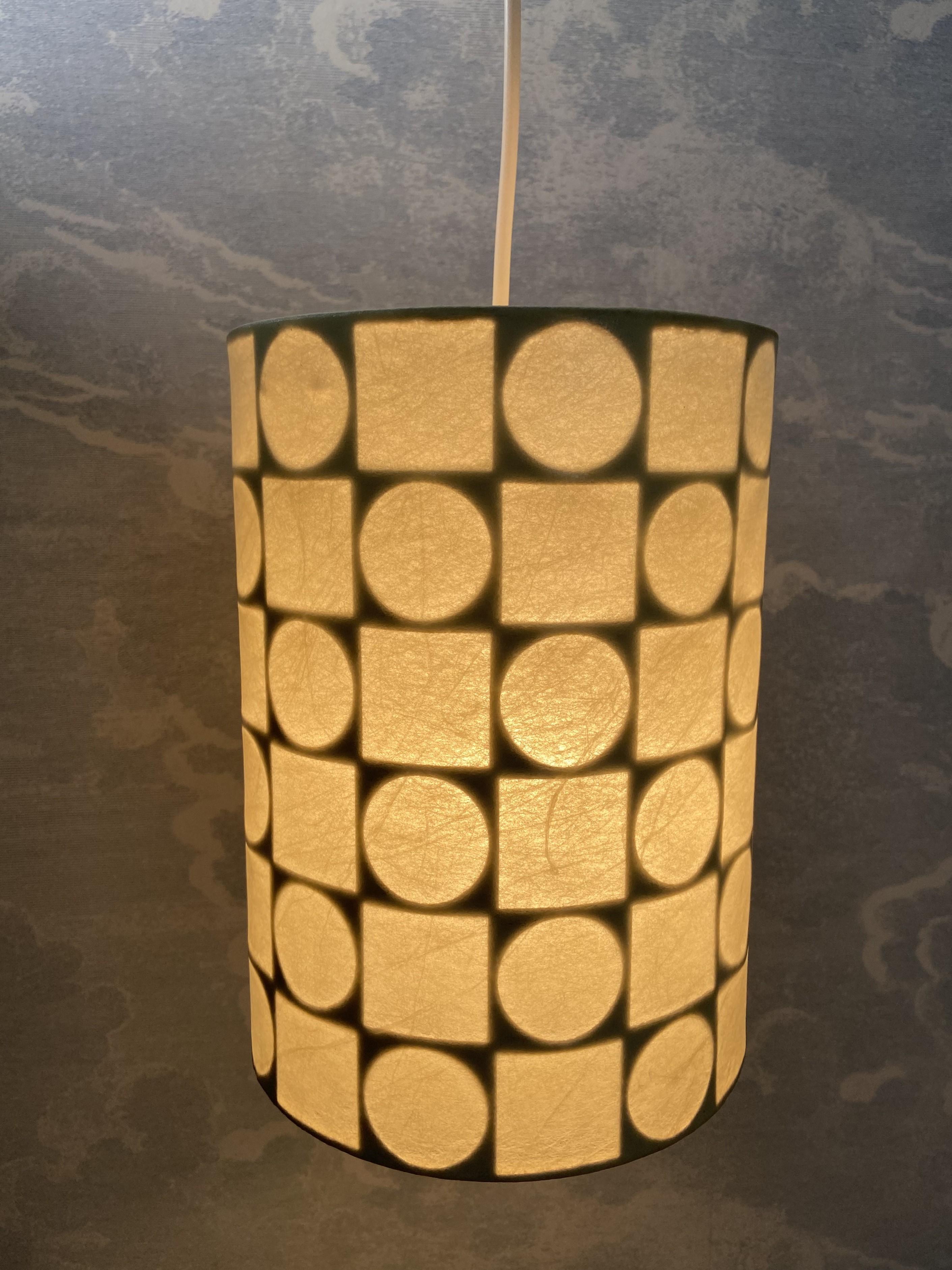 Ben proporzionata e con una bella luce calda diffusa, questa lampada a cilindro ha un aspetto da anni '60, con un motivo alternato di cerchi e quadrati.

Questa lampada a sospensione a forma di bozzolo è in ottime condizioni ed è stata realizzata da