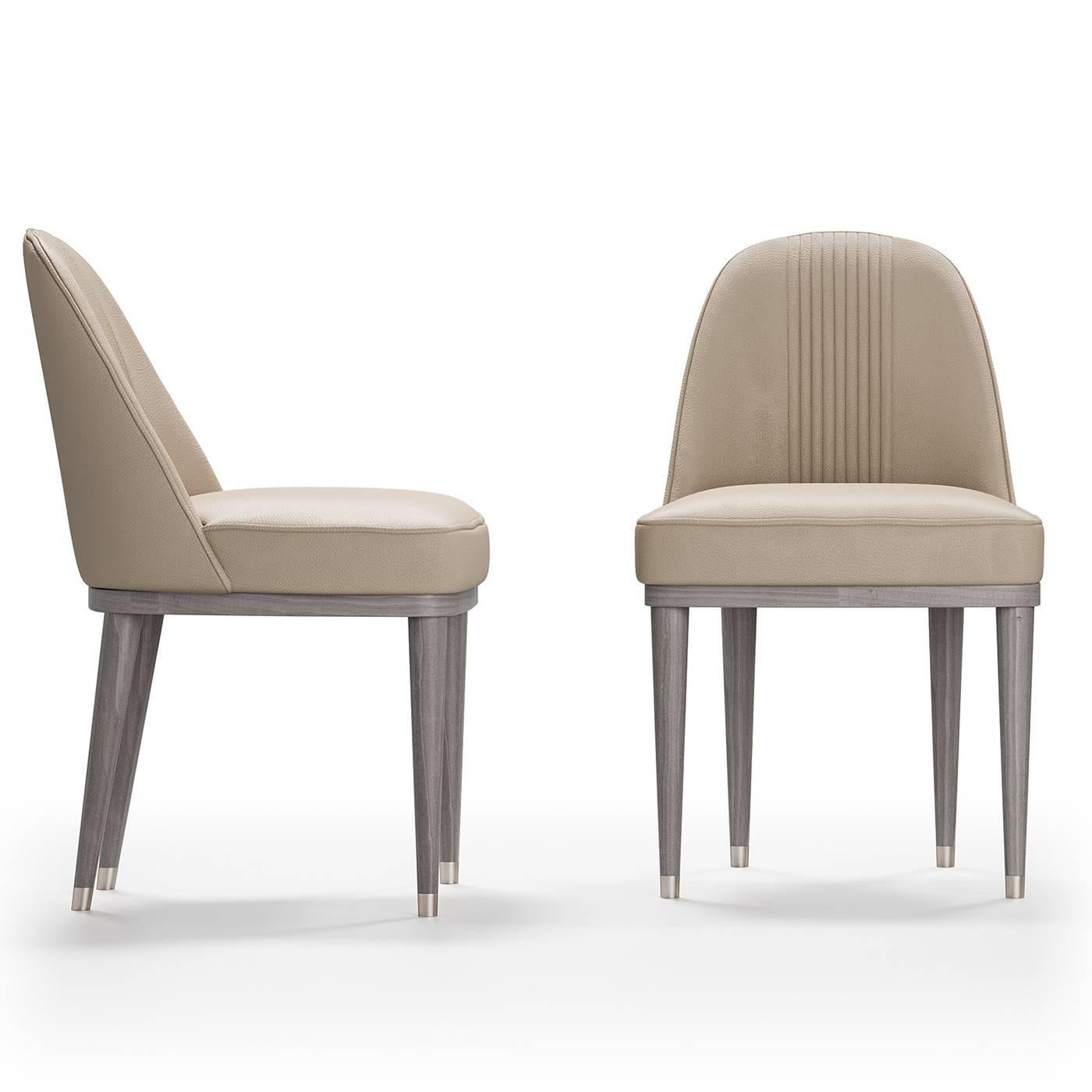 Des lignes épurées et des détails complexes caractérisent cette chaise intemporelle qui ajoutera un accent sophistiqué à une table de style moderne. Le cadre sans bras est soutenu par quatre pieds coniques et élancés avec des ferules en métal
