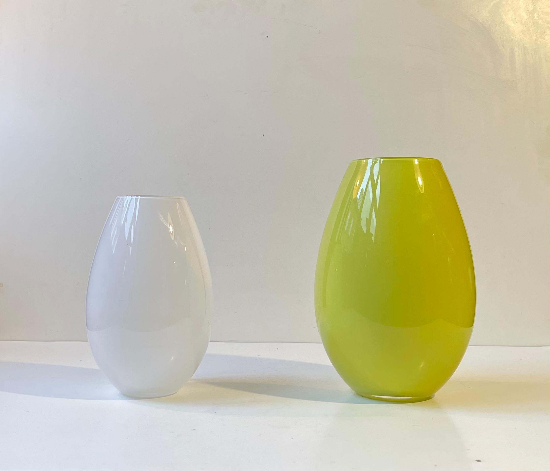 Eleganti vasi da fiori soffiati a mano in vetro opalino verde e bianco. Progettato da Peter Svarrer e prodotto da Holmegaard in Danimarca negli anni '90 o nei primi anni 2000. 

Misure: H: 21/17 cm, Diametro: 13/11 cm.   

Entrambi i vasi sono